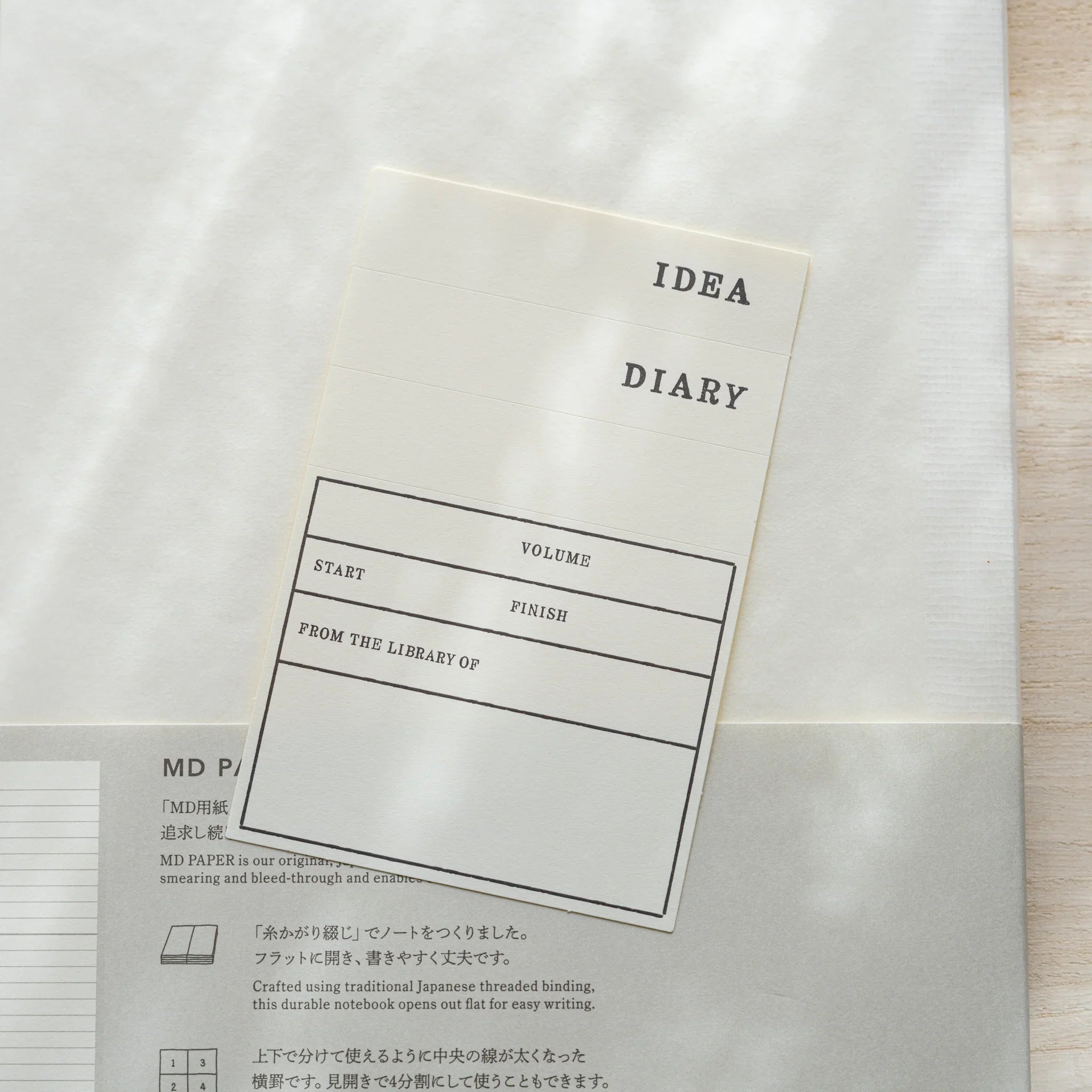 Midori MD Notebook A5 Lined belly band open showing IDEA Diary label with Volume, Start, Finish, and From Library Of fields