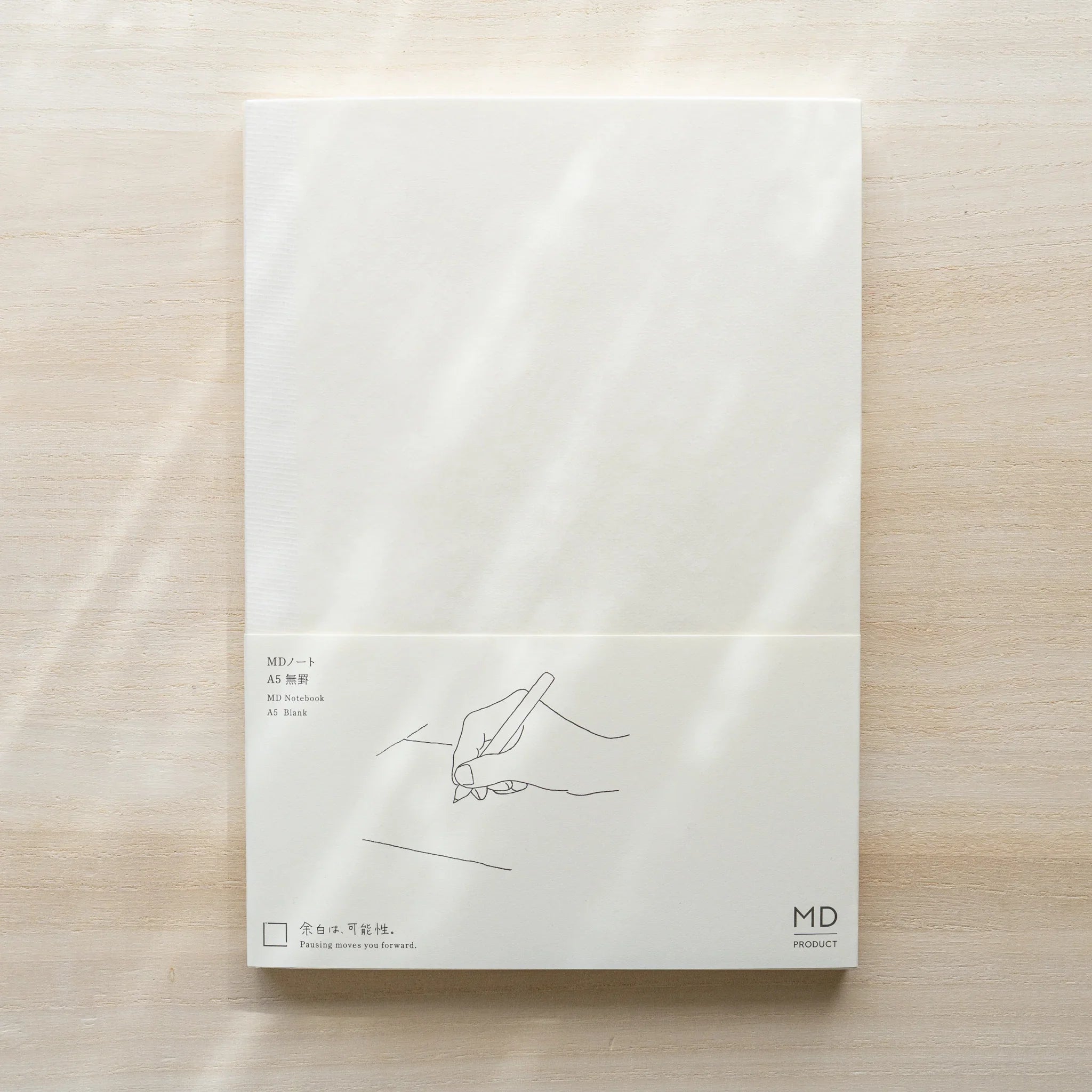 Midori MD Notebook A5 Blank in glassine wrapping, belly band with hand writing illustration, text MD Notebook A5 Blank