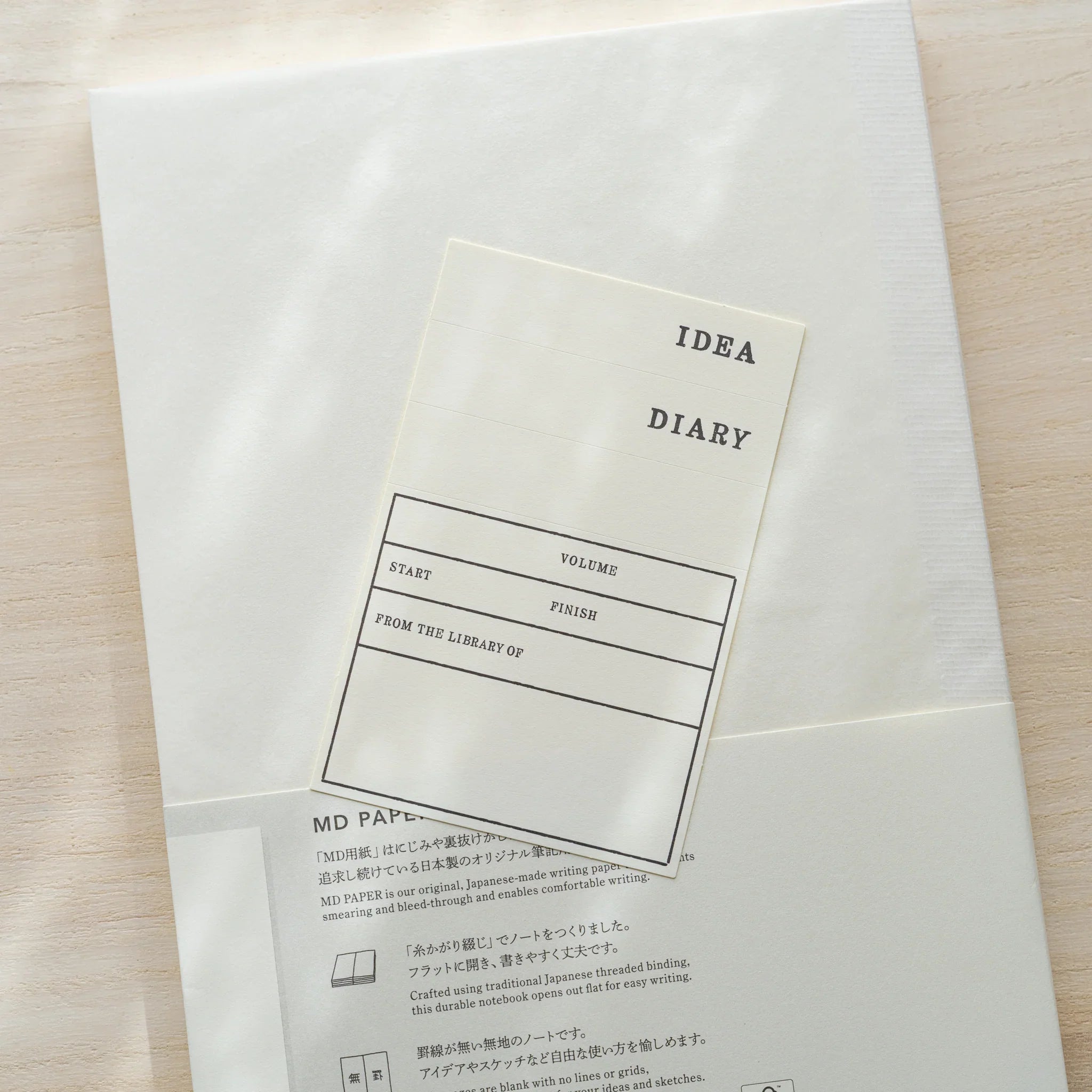 Midori MD Notebook A5 in glassine wrapping, close-up of belly band IDEA Diary fill-in label with Volume, Start, Finish fields