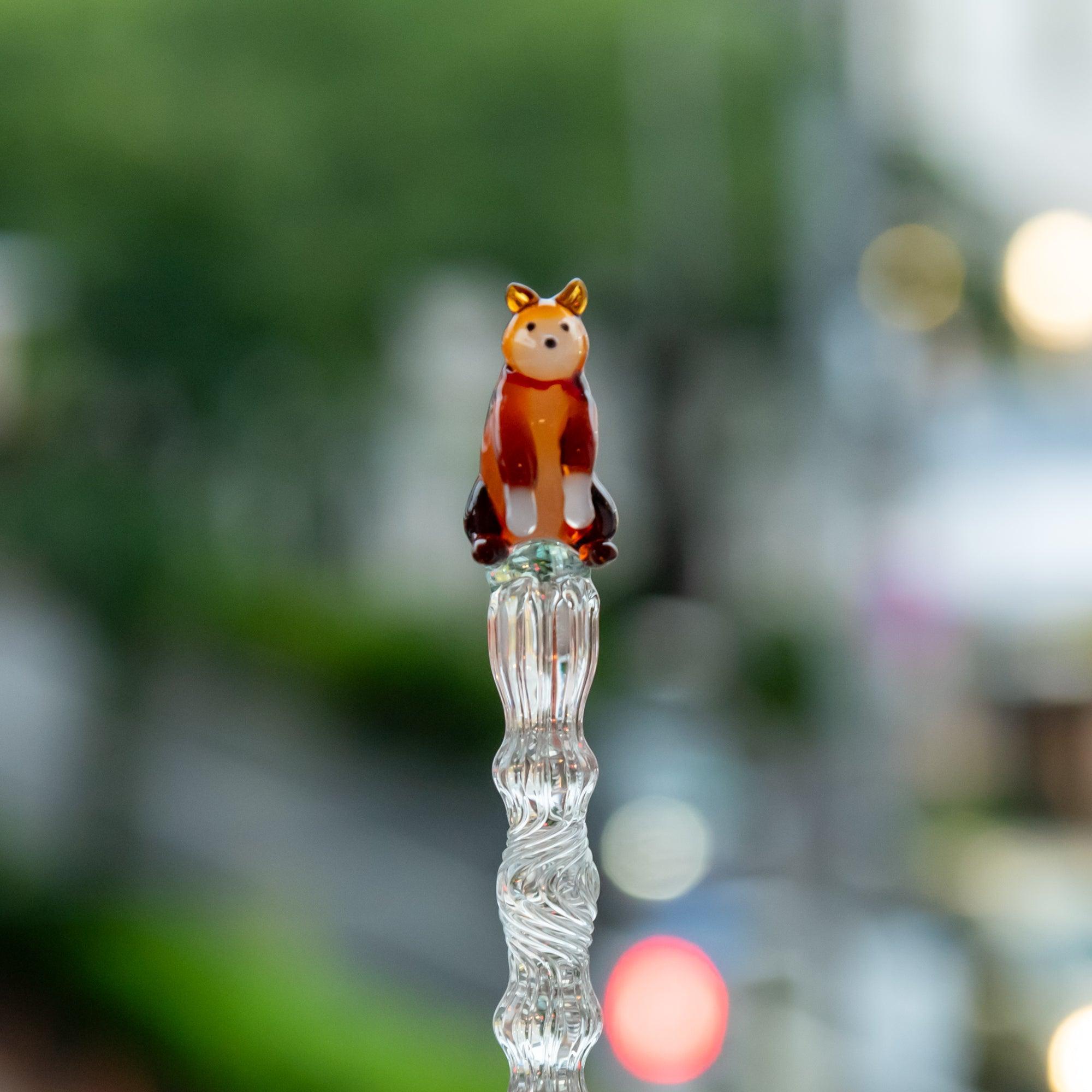 Shiba Inu glass pen with a clear light green shaft, held in hand outdoors. A beautiful addition to any stationery collection.
