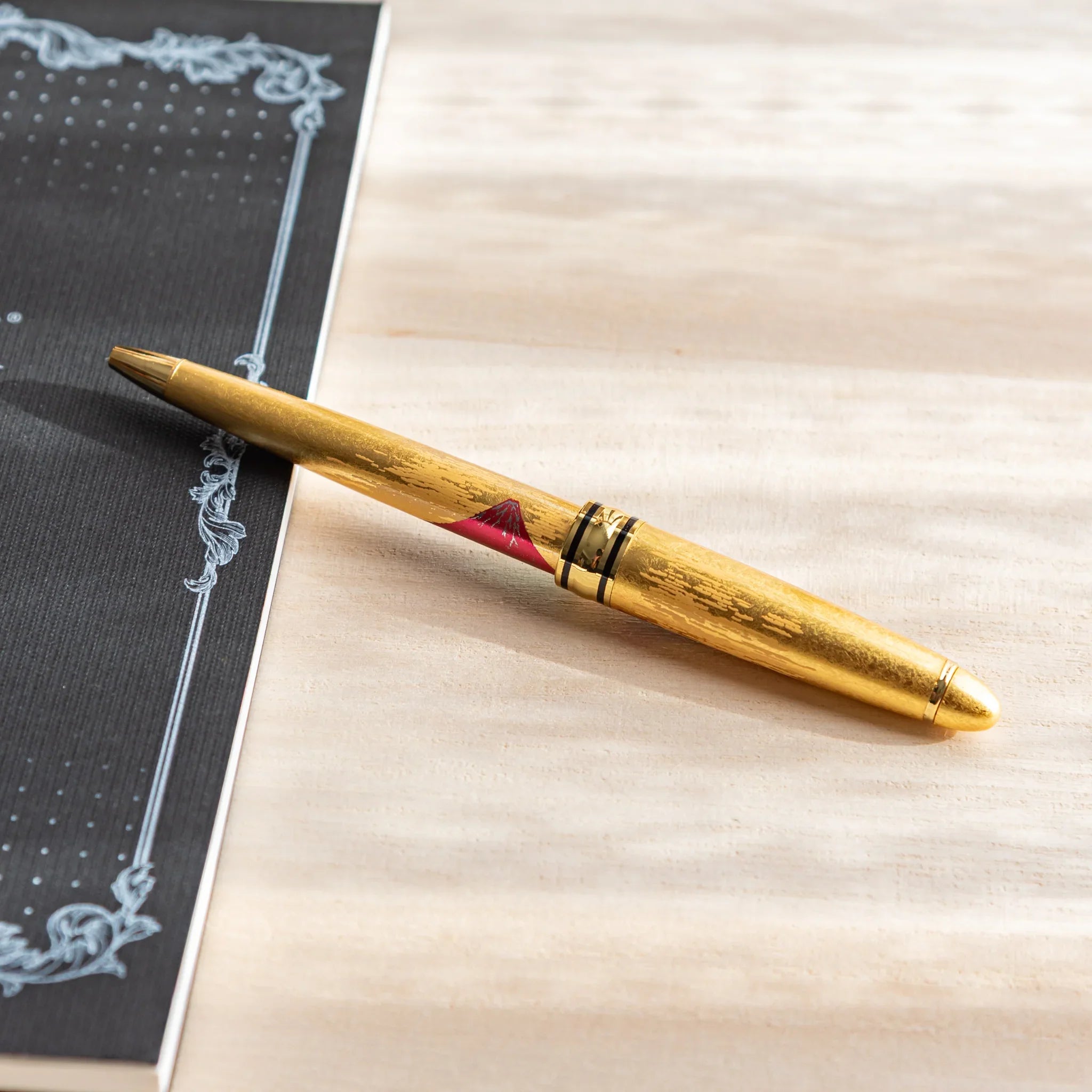 Black ballpoint pen with gold trim and Mt. Fuji maki-e decoration design displayed clearly composition