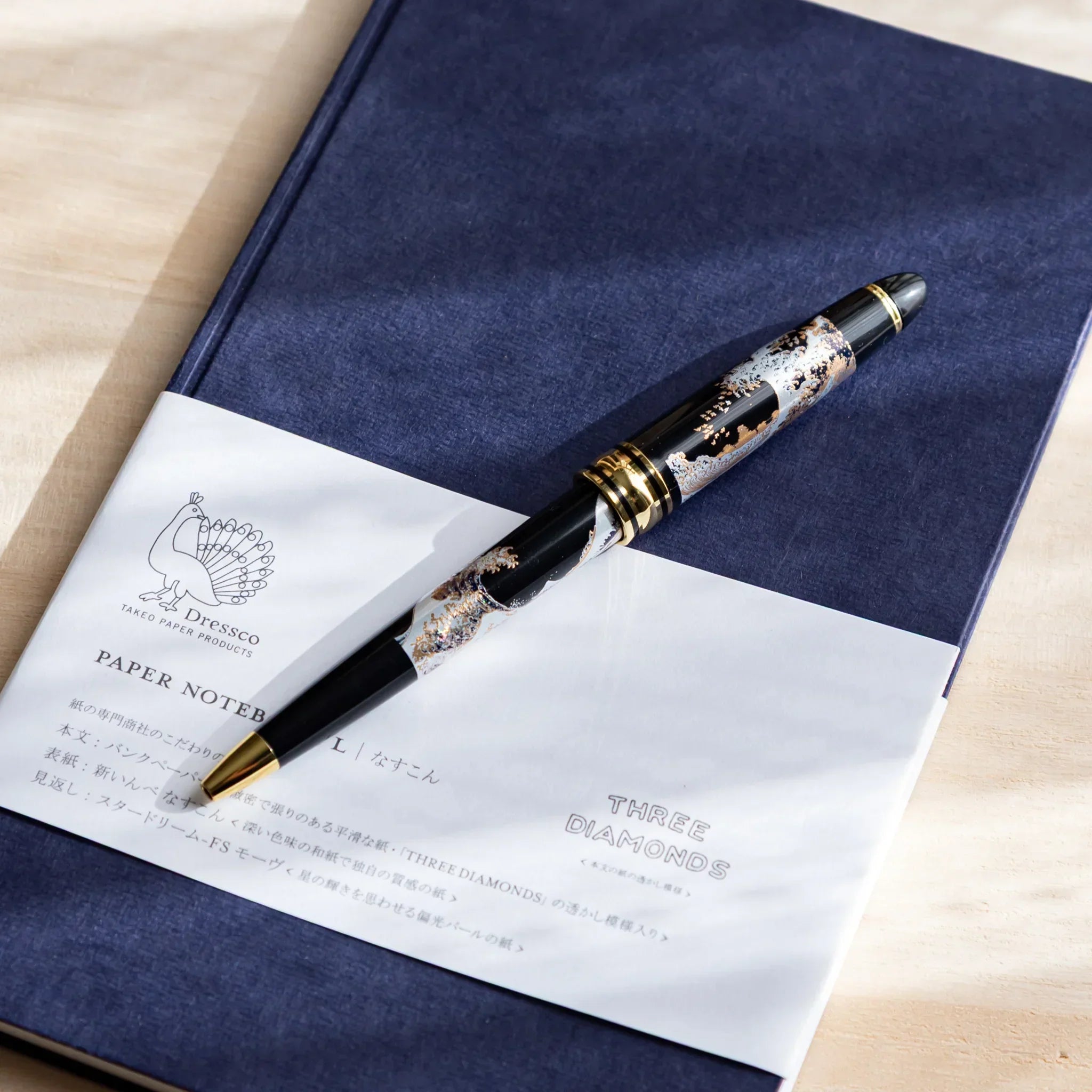 Hokusai Great Wave ballpoint with gold trim and traditional lacquer finish shown in composition composition shown