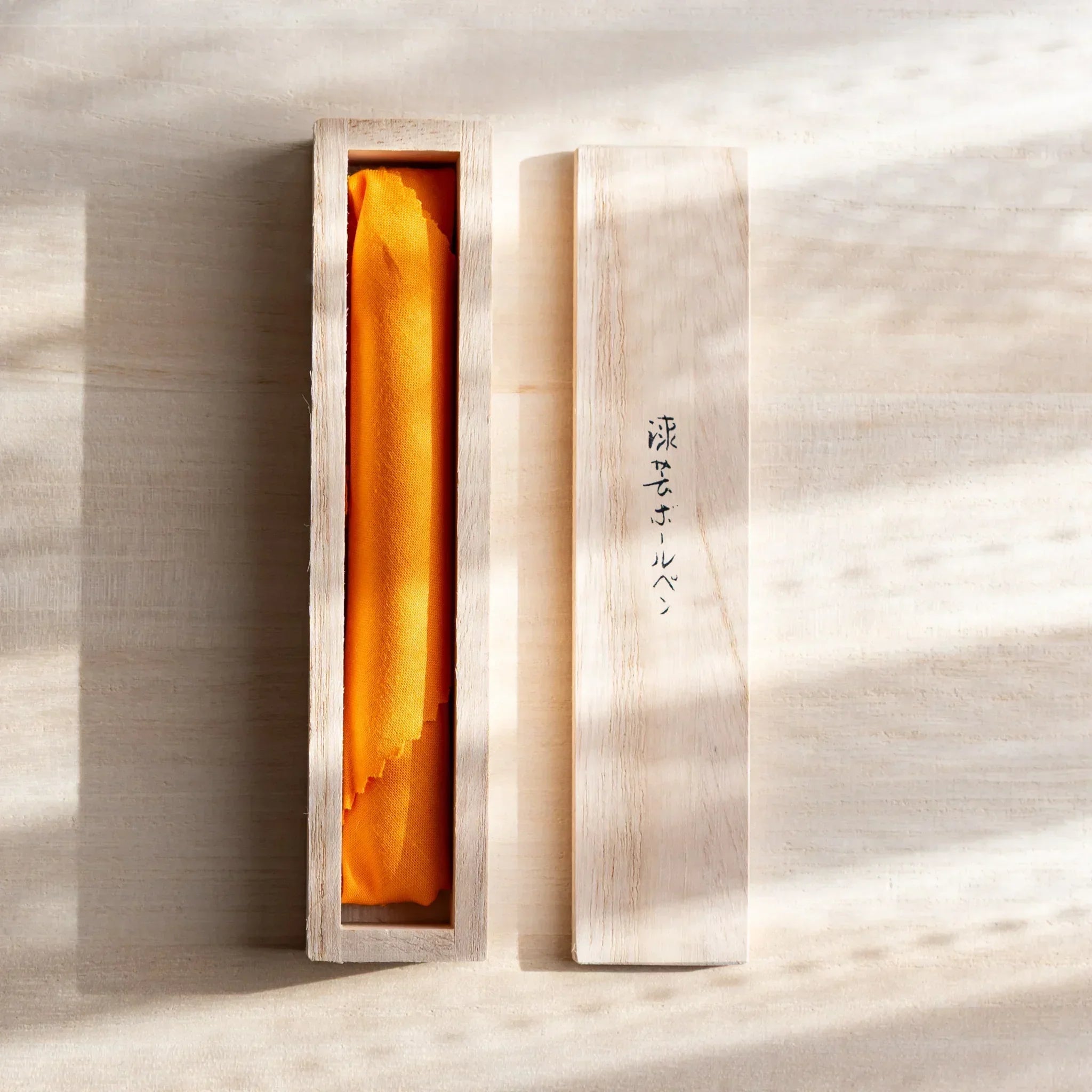 Open wooden box with orange lining and lid with Japanese script for Japanese Ballpoint Pen.