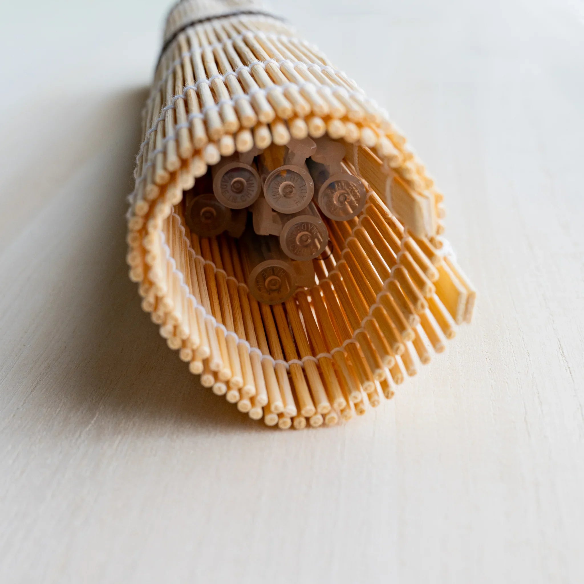 Akashiya fudemaki bamboo brush roll on a light wood background, a Japanese brush care accessory