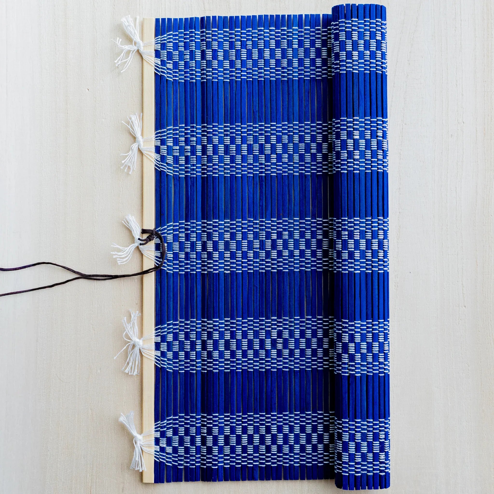 Akashiya fudemaki brush wrap in blue, partly rolled to show interior weave