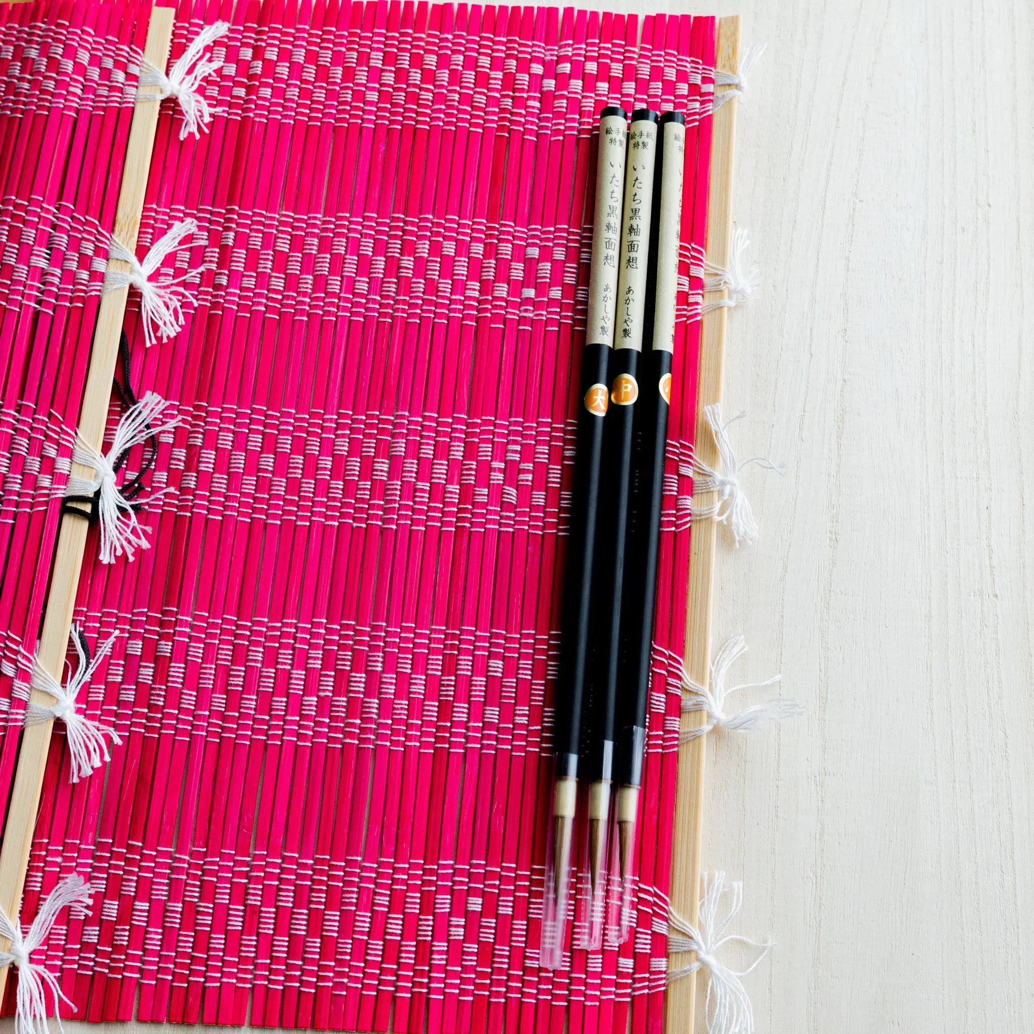 Akashiya bamboo brush roll, red, with cotton cord clasp visible
