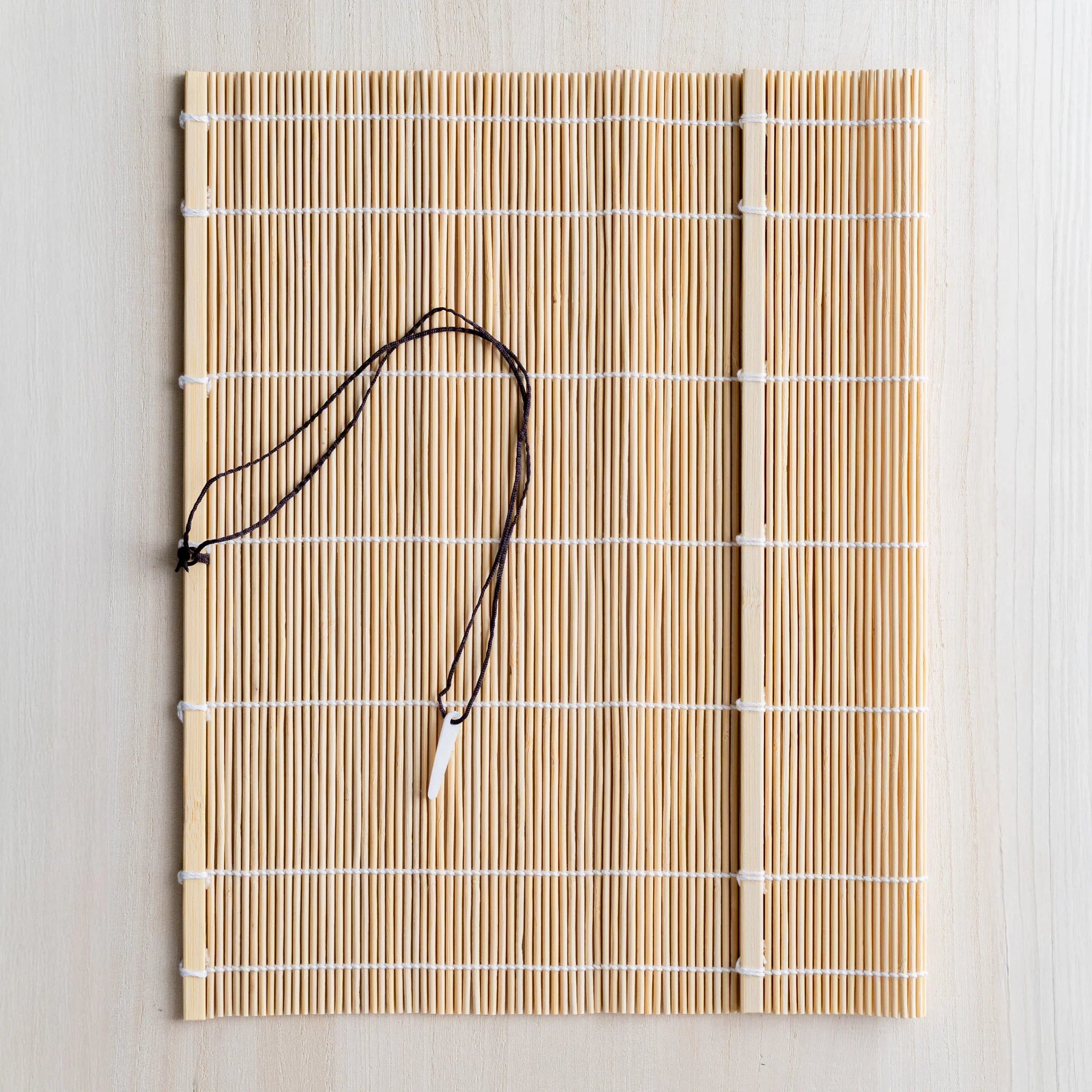 Akashiya bamboo brush roll laid open showing the woven bamboo mat for protecting brush tips while drying