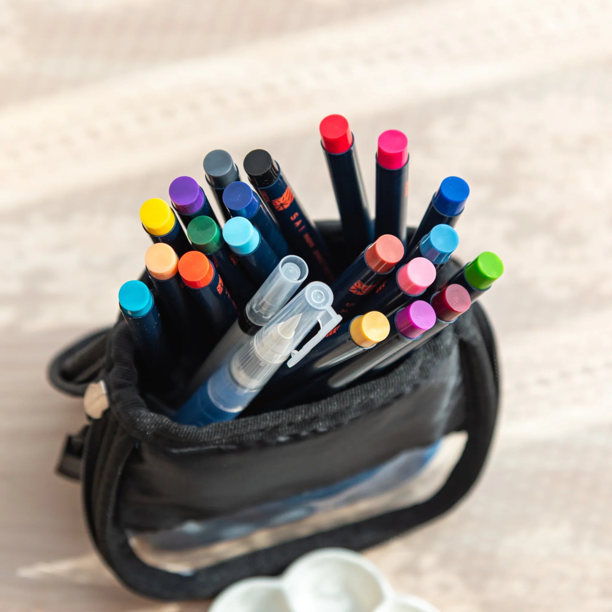 Blue denim fabric pen case with visible Akashiya branding and zipper closure for portable art supply storage