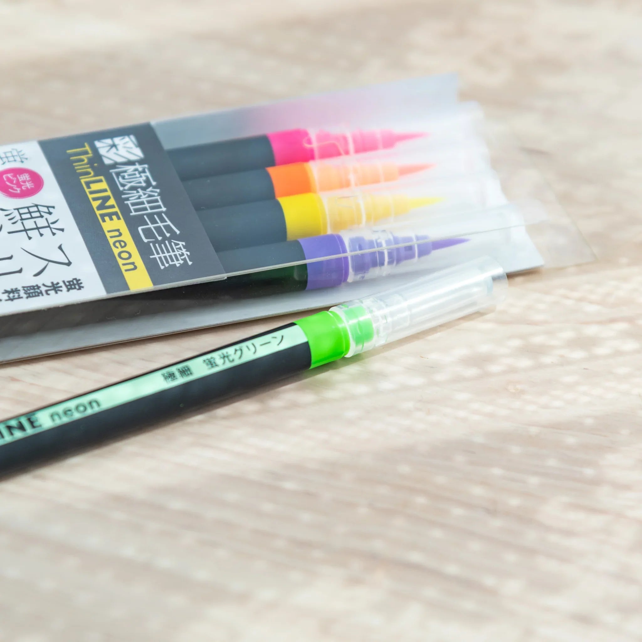 Neon brush pens arranged by color showing range from hot pink to yellow to bright green watercolor tones