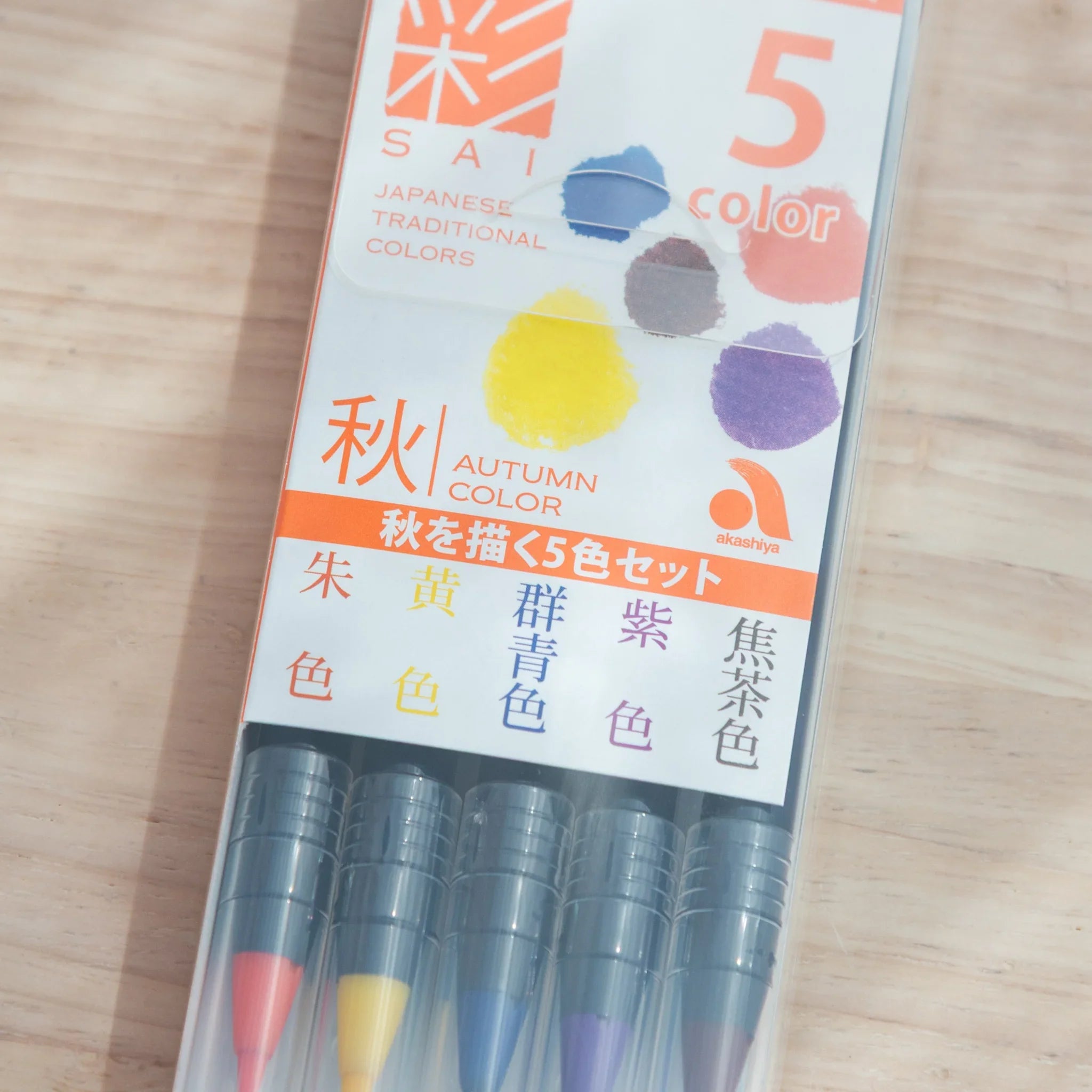 Autumn color brush pens grouped together displaying fall-inspired warm earth-tone pigment palette set