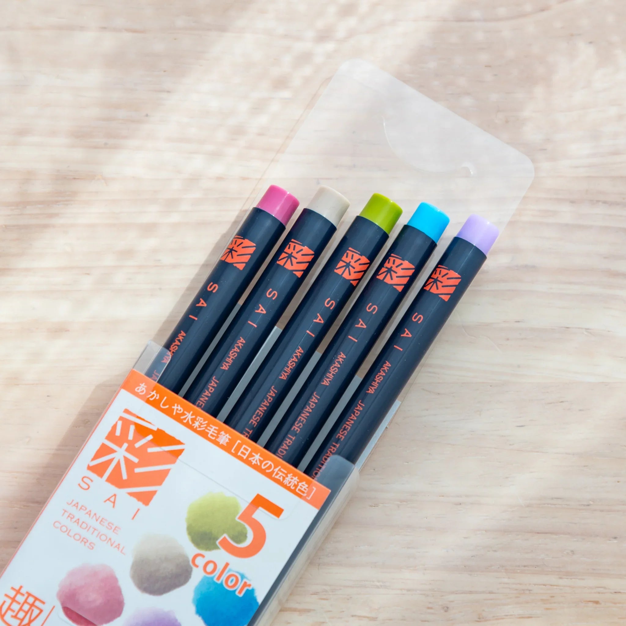 Five muted subtle watercolor brush pens showing soft neutral tones with gently reduced pigment saturation