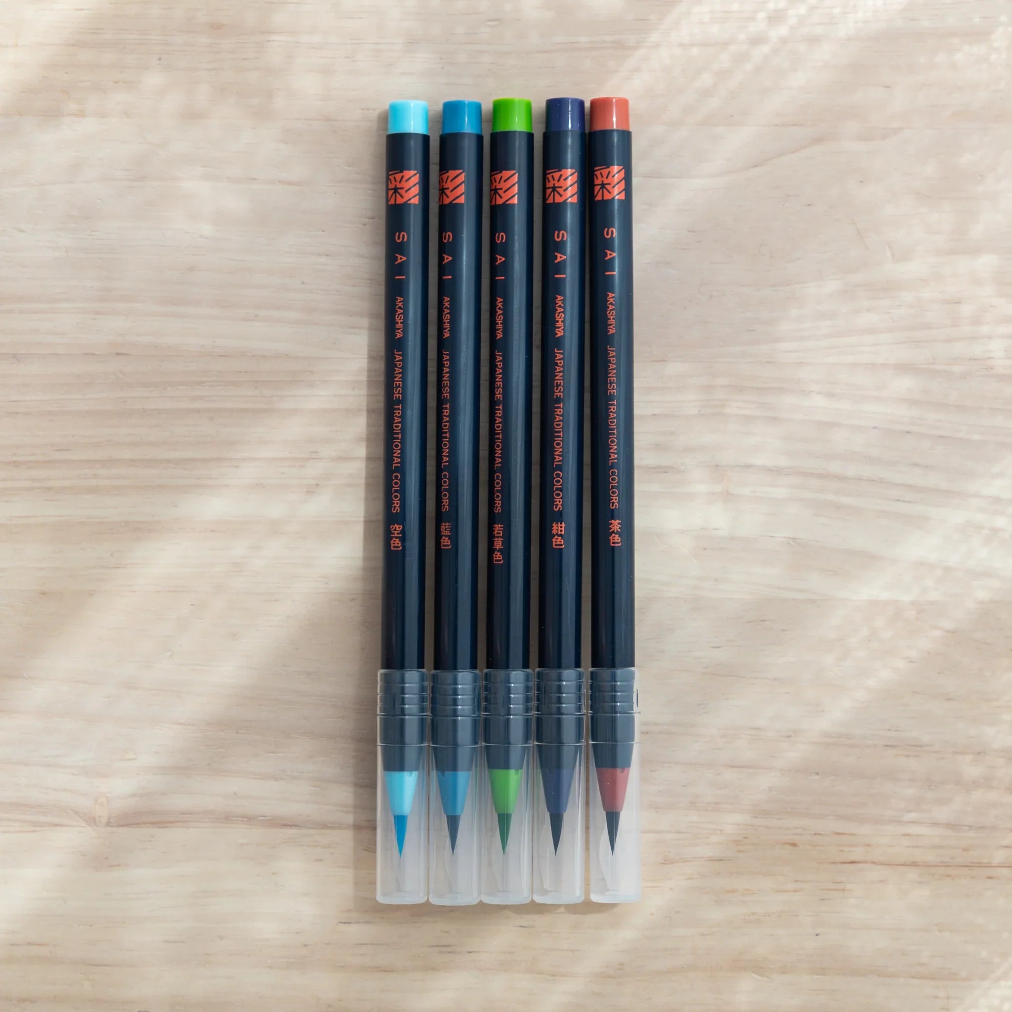 Five bright vibrant summer watercolor brush pens showing tropical colors including turquoise, coral, lime