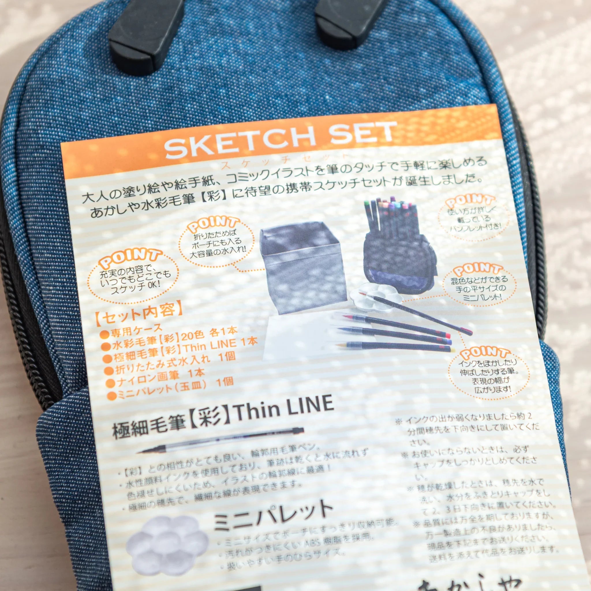 Denim case with all kit contents organized showing brush pens and folding water cup for complete set
