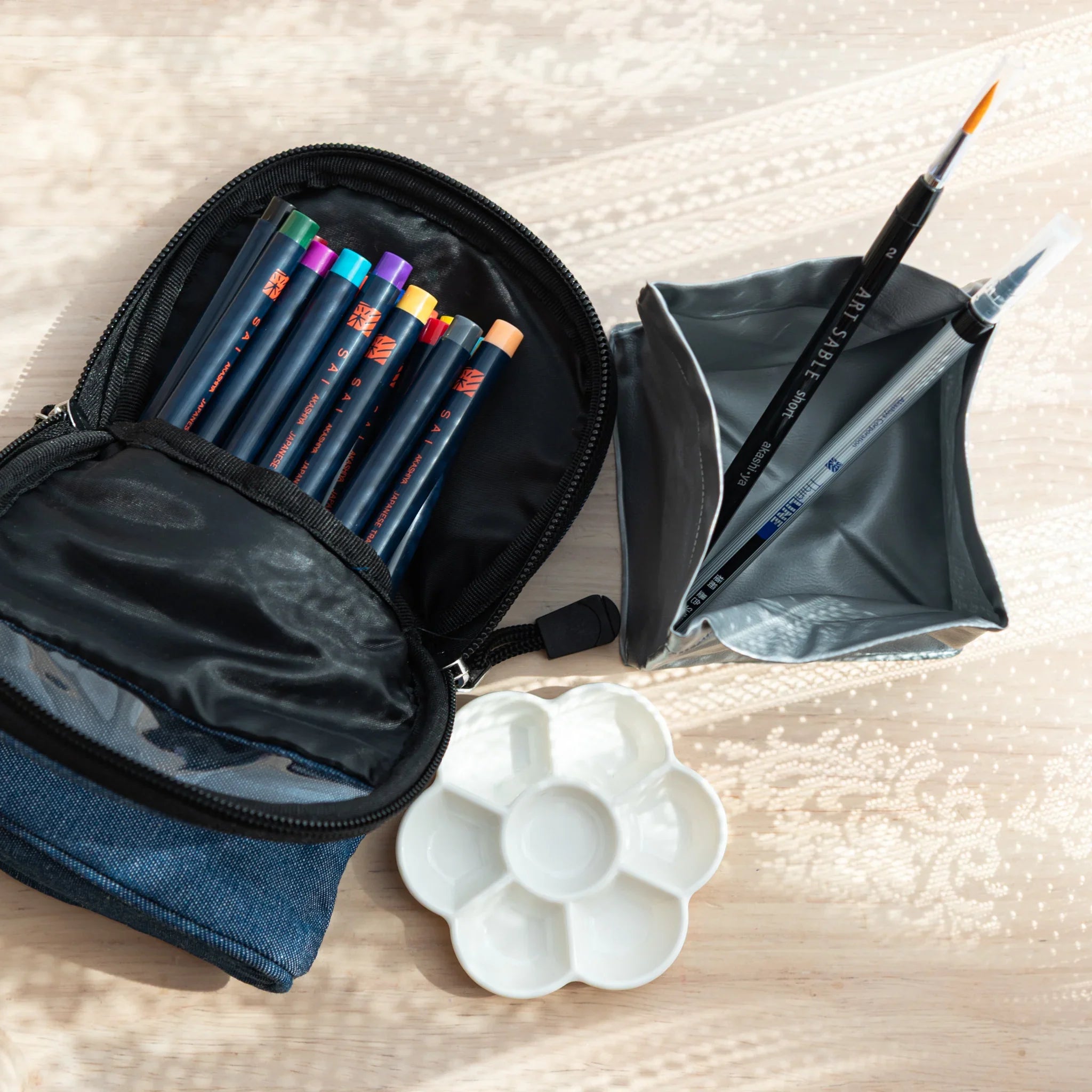 Blue denim carrying case with zipper closure for storing watercolor brush pens and art supplies securely