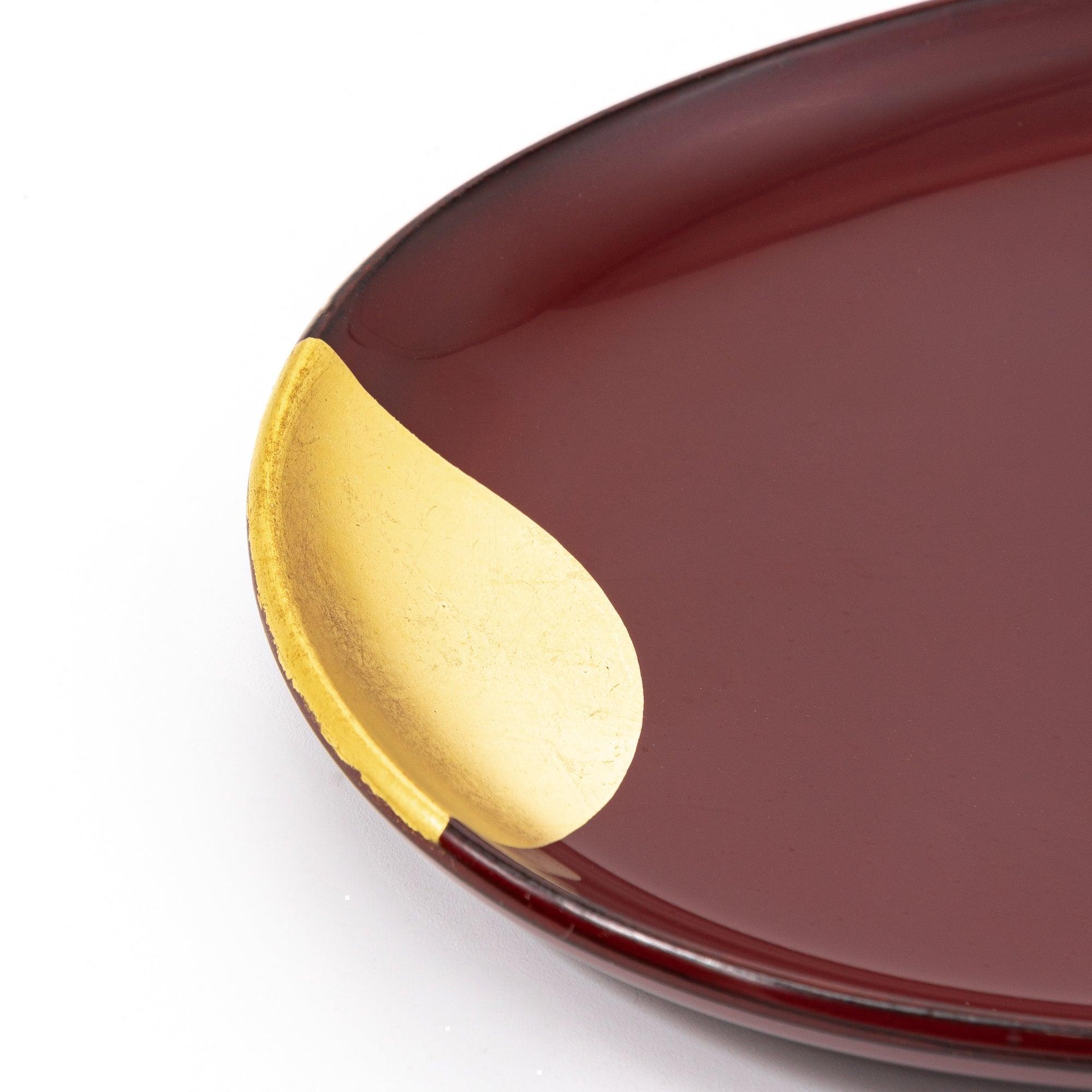 Close-up of the gold-accented corner of a red lacquer tray, showcasing its fine details and smooth texture. Beautiful authentic Japanese stationery.