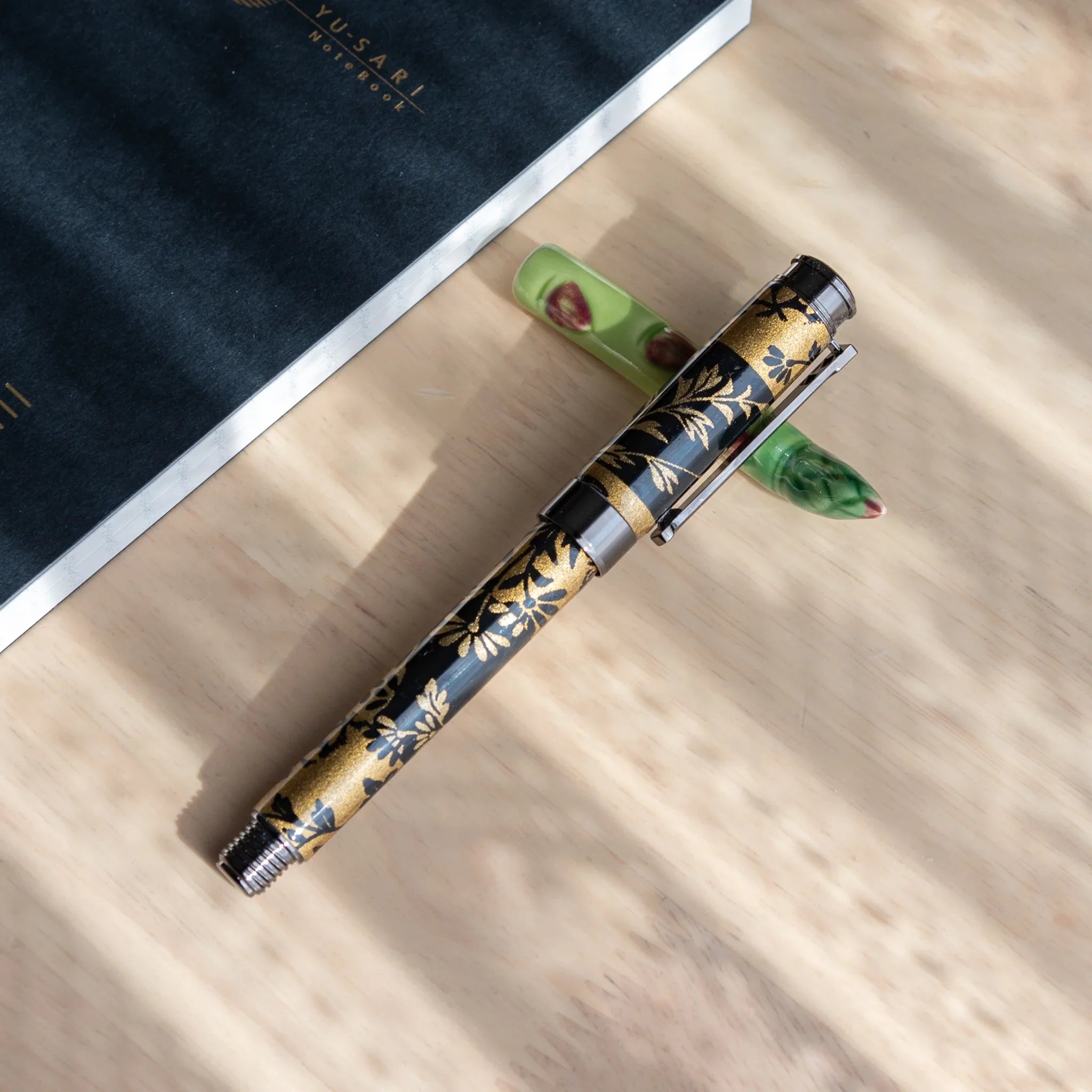 Jade green asparagus-shaped handcrafted ceramic pen rest featuring realistic bundled spear form overall close shot