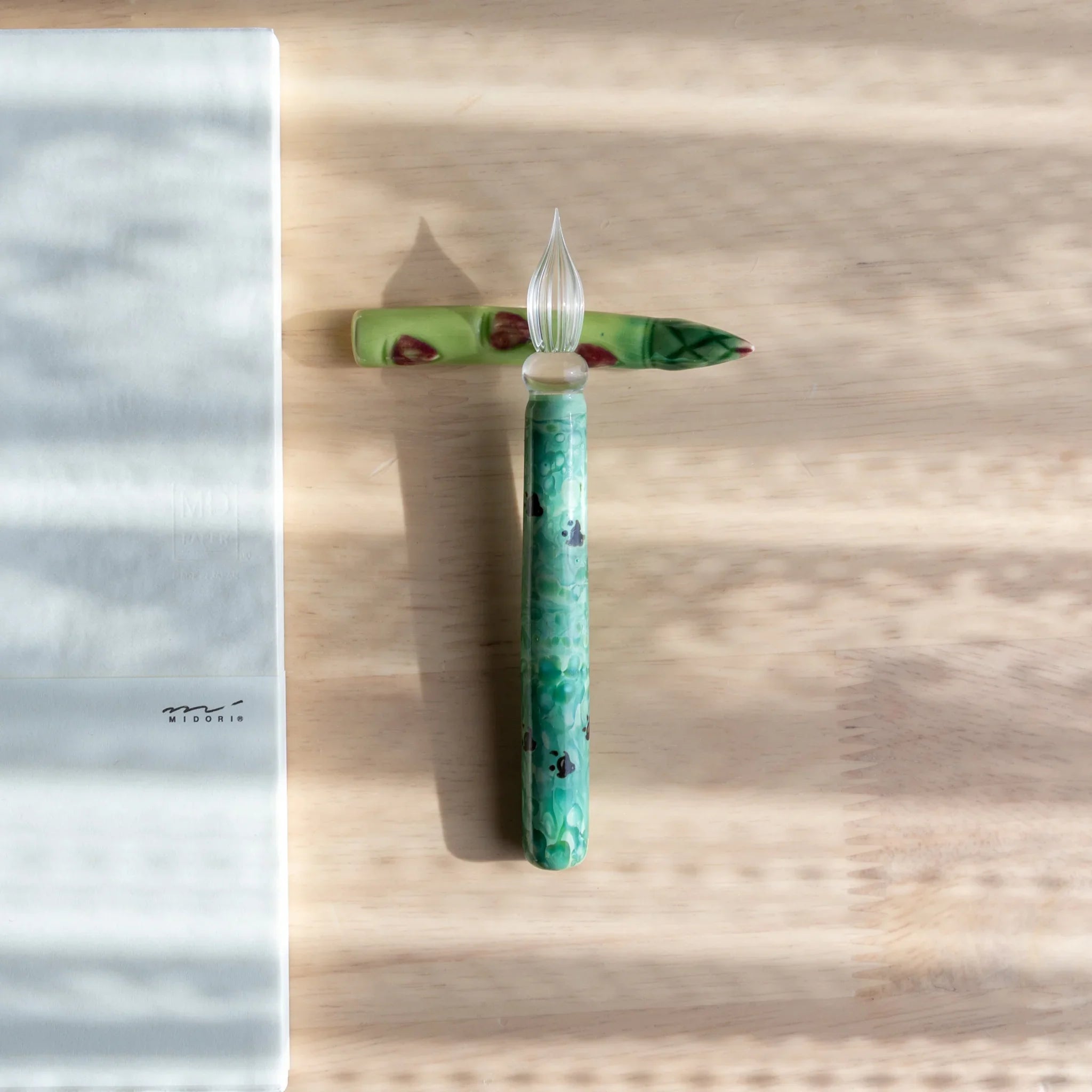 Vibrant green asparagus handcrafted ceramic pen rest with natural vegetable appearance and groove slot close shot