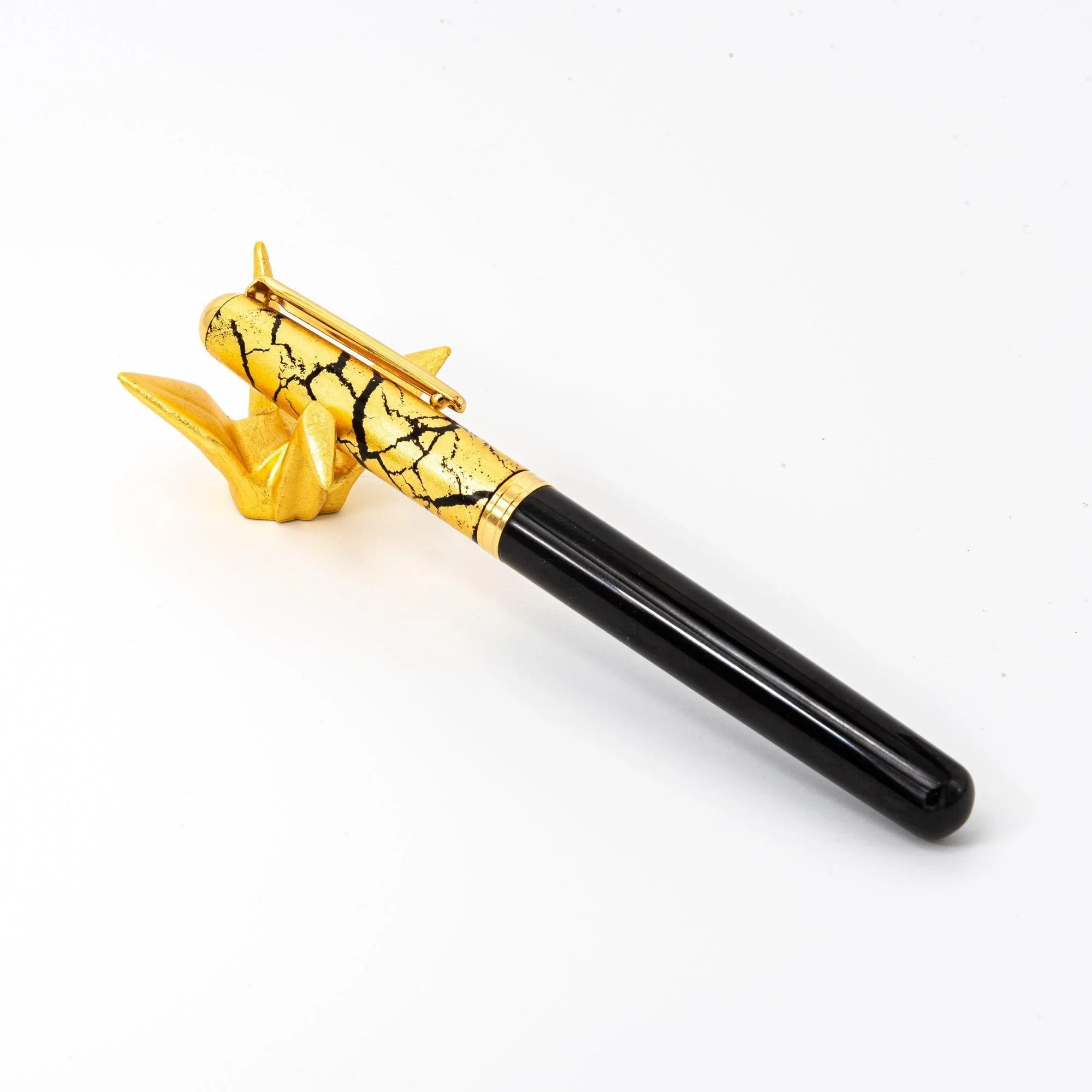 Two Japanese ceramic gold crane pen rests with golden crackle pattern displayed on white surface, overhead view