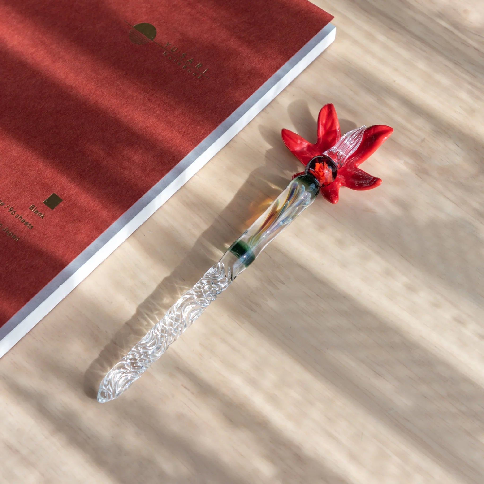 Detailed autumn leaf pen rest with red and brown colorway showing carved leaf texture detail and seasonal color gradient