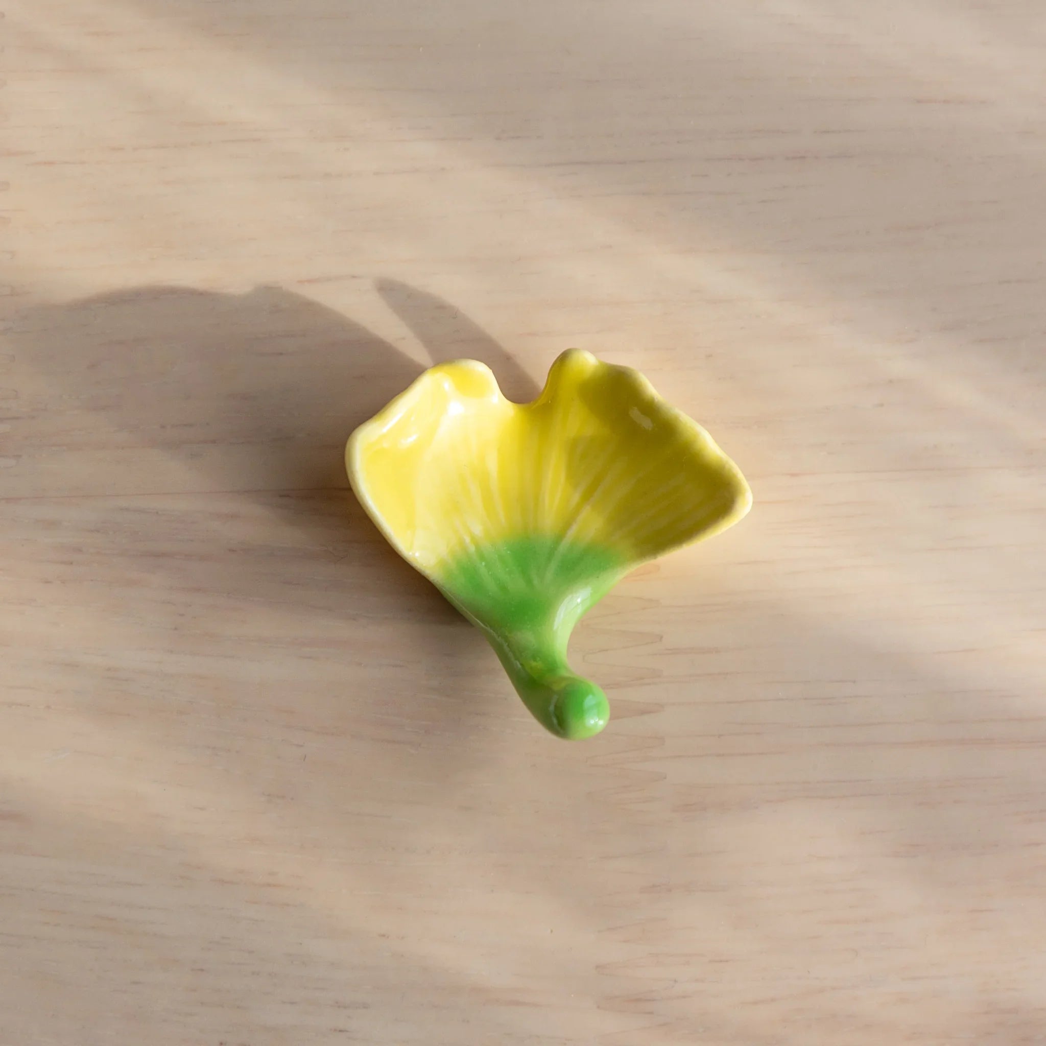 Red-brown autumn maple leaf pen rest with carved detail showing seasonal Japanese design theme and natural leaf structure