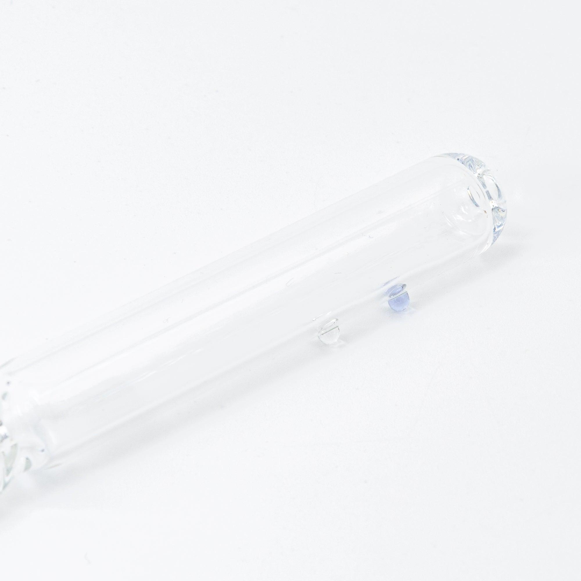 A clear glass dip pen with a small blue candy-shaped glass motif captured inside its shaft. The pen’s nib is intricately designed, enhancing the overall charm.