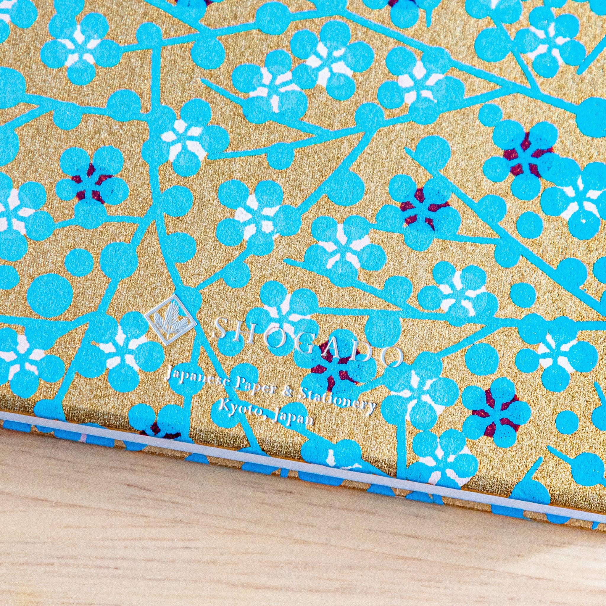 Blue Flower Goshuincho stamp book detail showing turquoise washi cover with hand-drawn flower pattern and gold accents