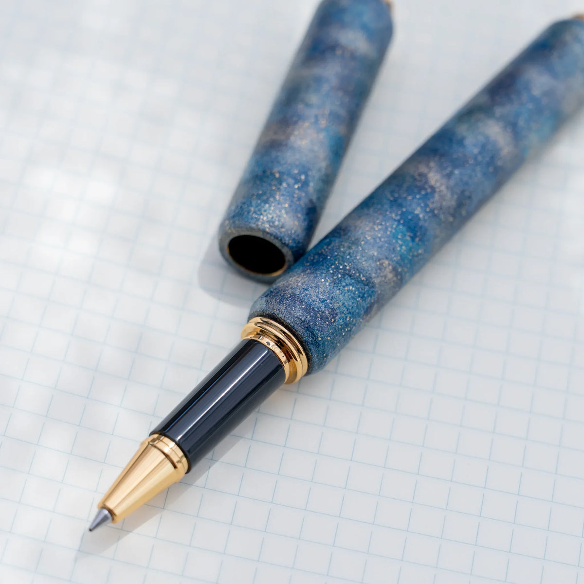 Gold trimmed rollerball tip of the blue marbled urushi lacquered rollerball pen