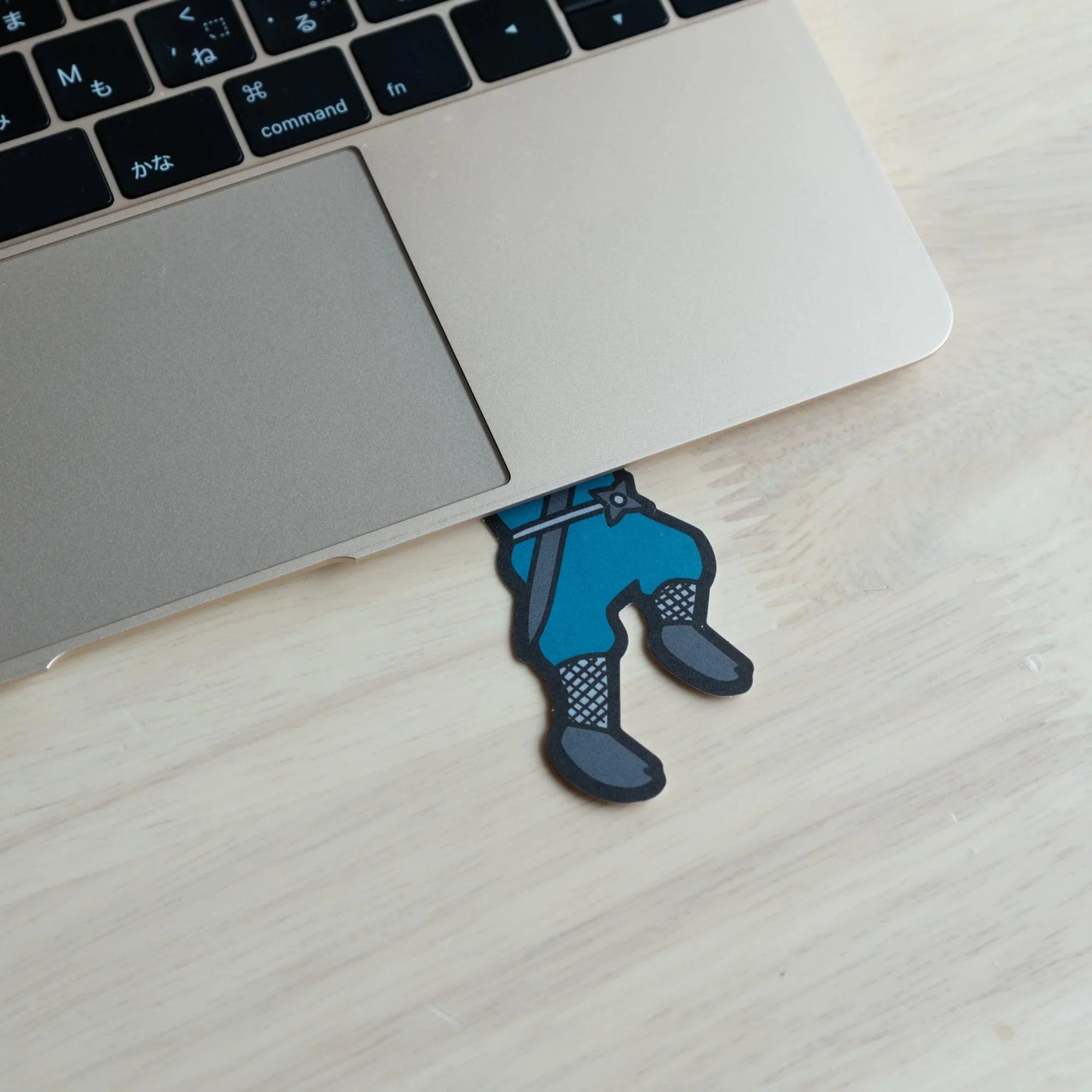 Blue ninja washi message card positioned next to laptop keyboard showing detailed character illustration