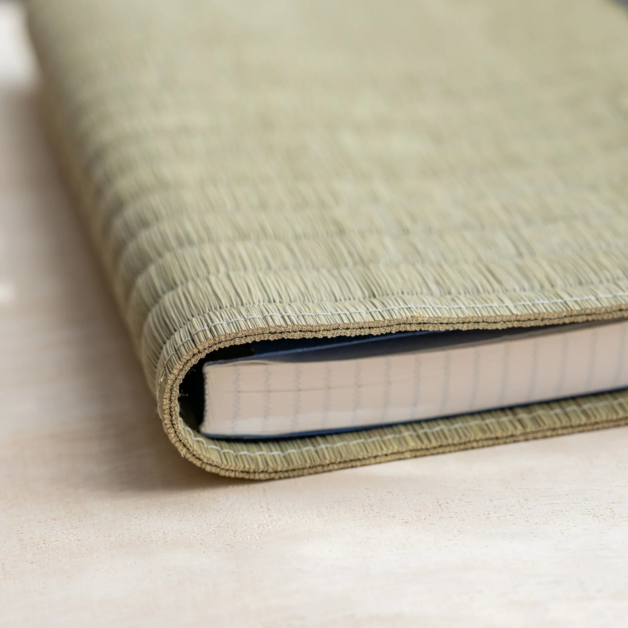 Close-up of the folded spine of the Blue Yachiyo tatami book cover with notebook pages and blue inner cover inside