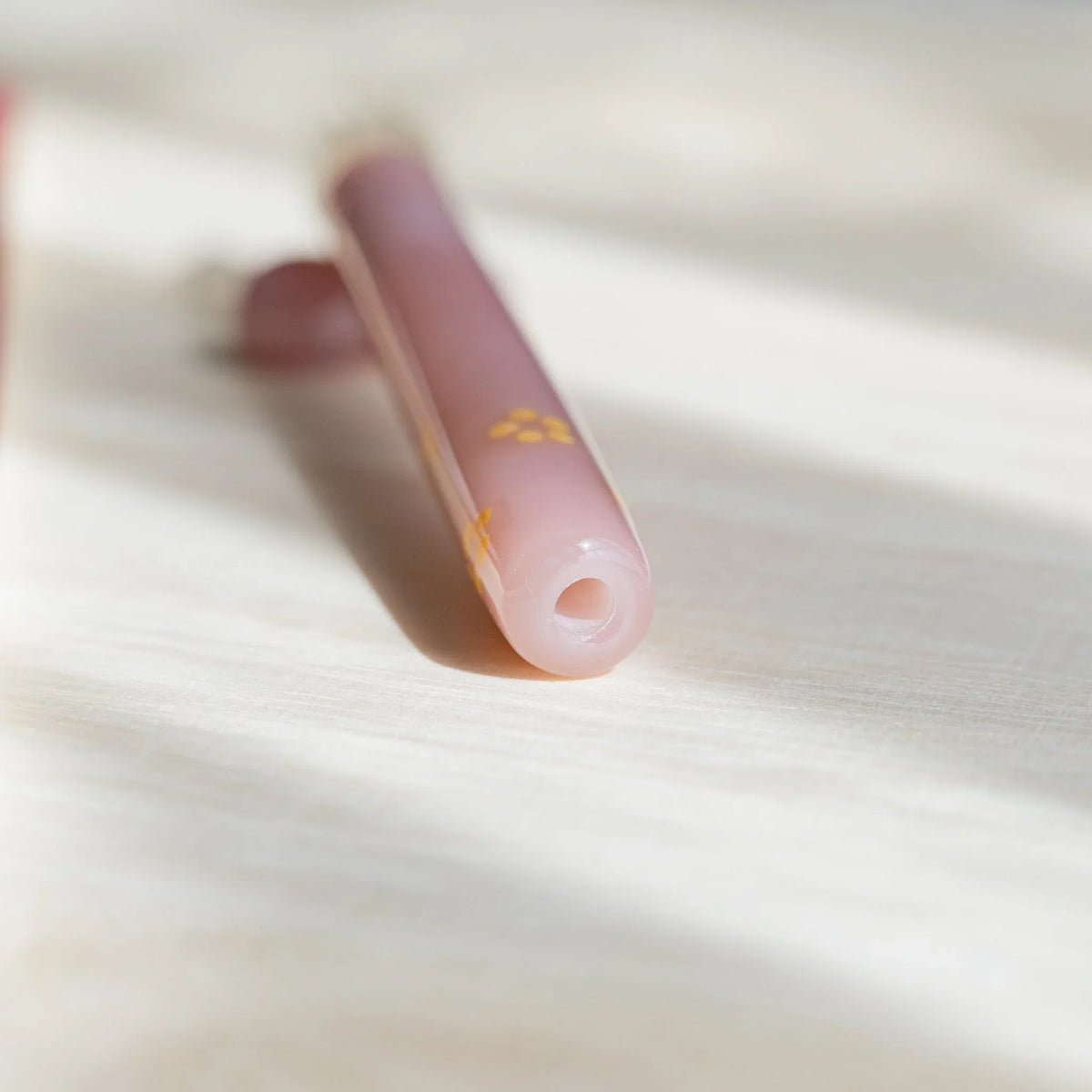 Close-up of the open end of the Blush Pink Flowers pen barrel showing the hollow pink glass tube