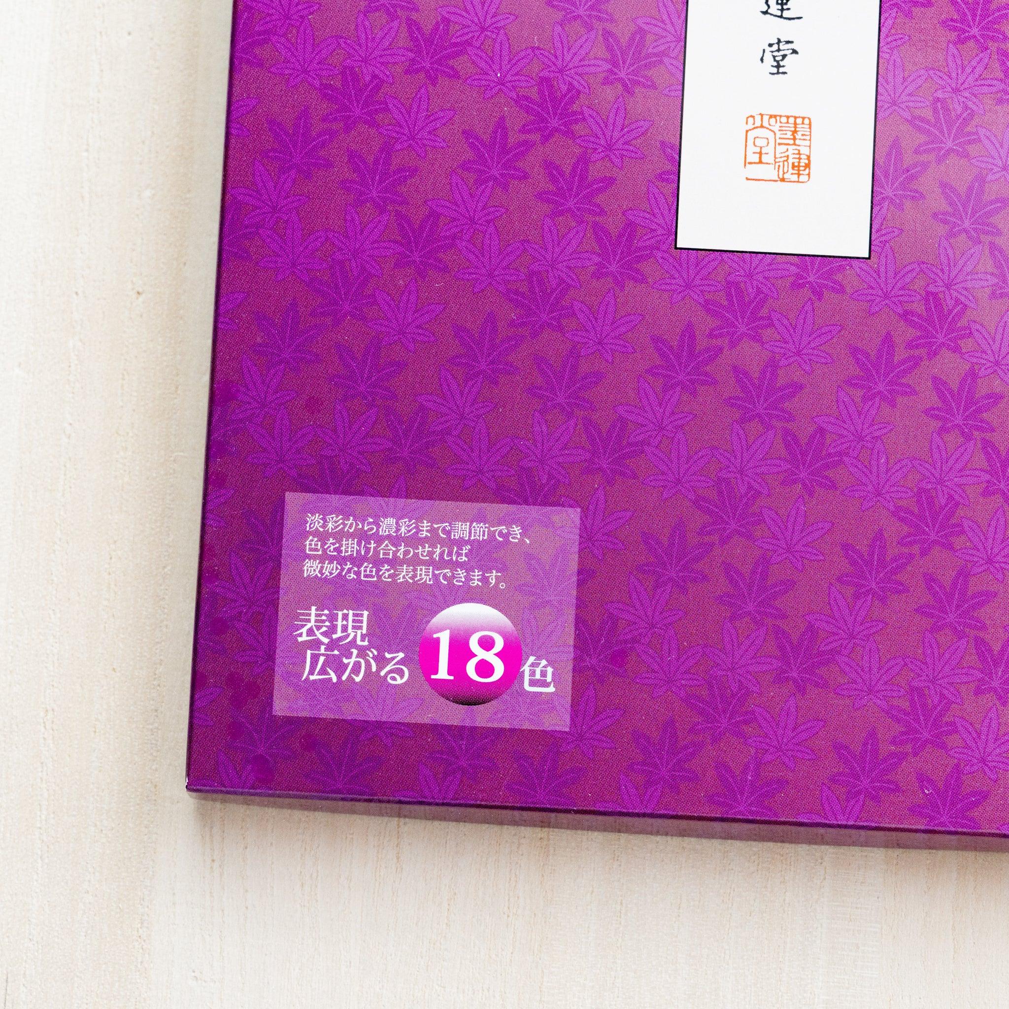 Close-up of corner of closed magenta Gansai box showing maple leaf pattern, brand seal, and 18-color expansion badge