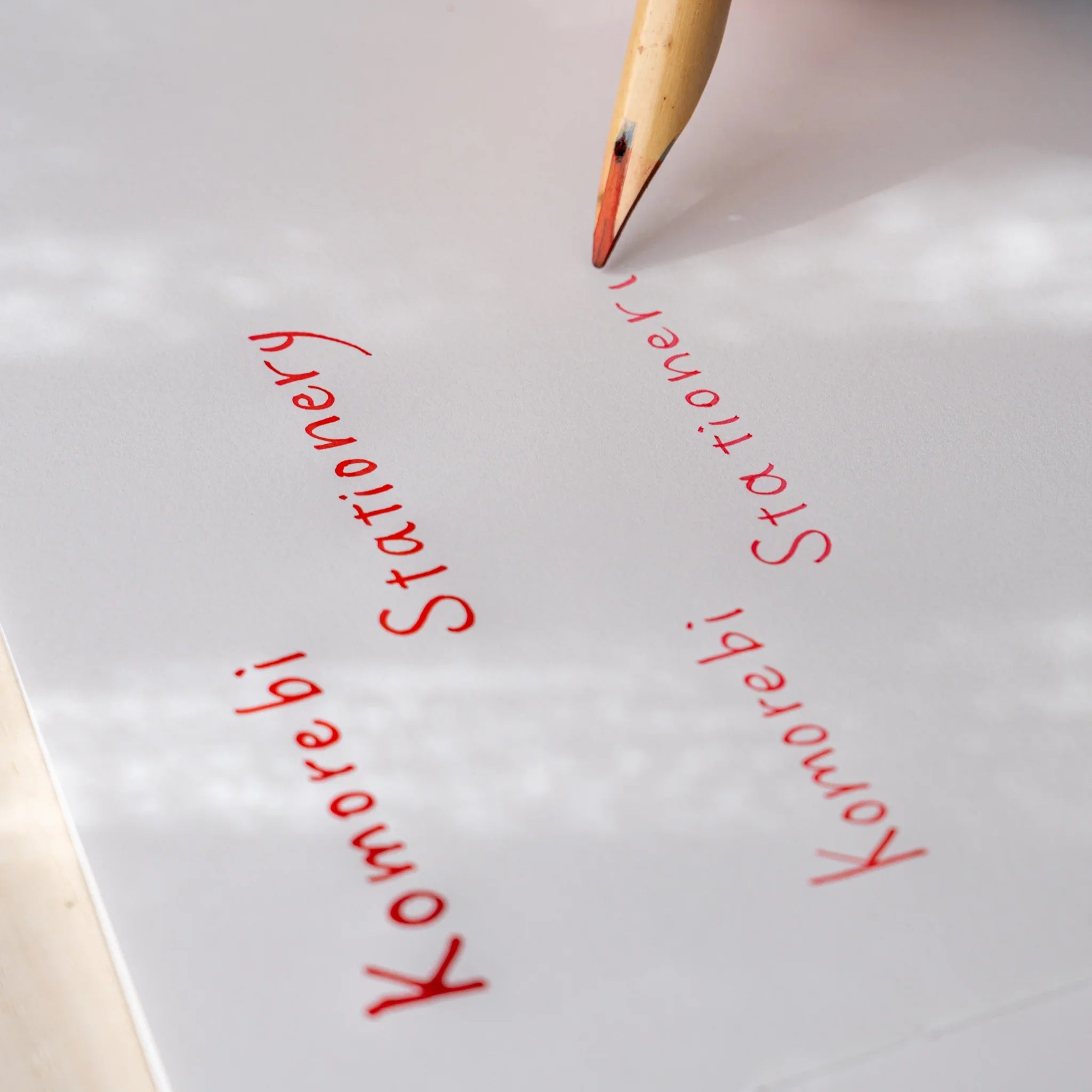 Close-up of Boku-Undo bamboo dip pen writing Komorebi Stationery in red ink on white paper
