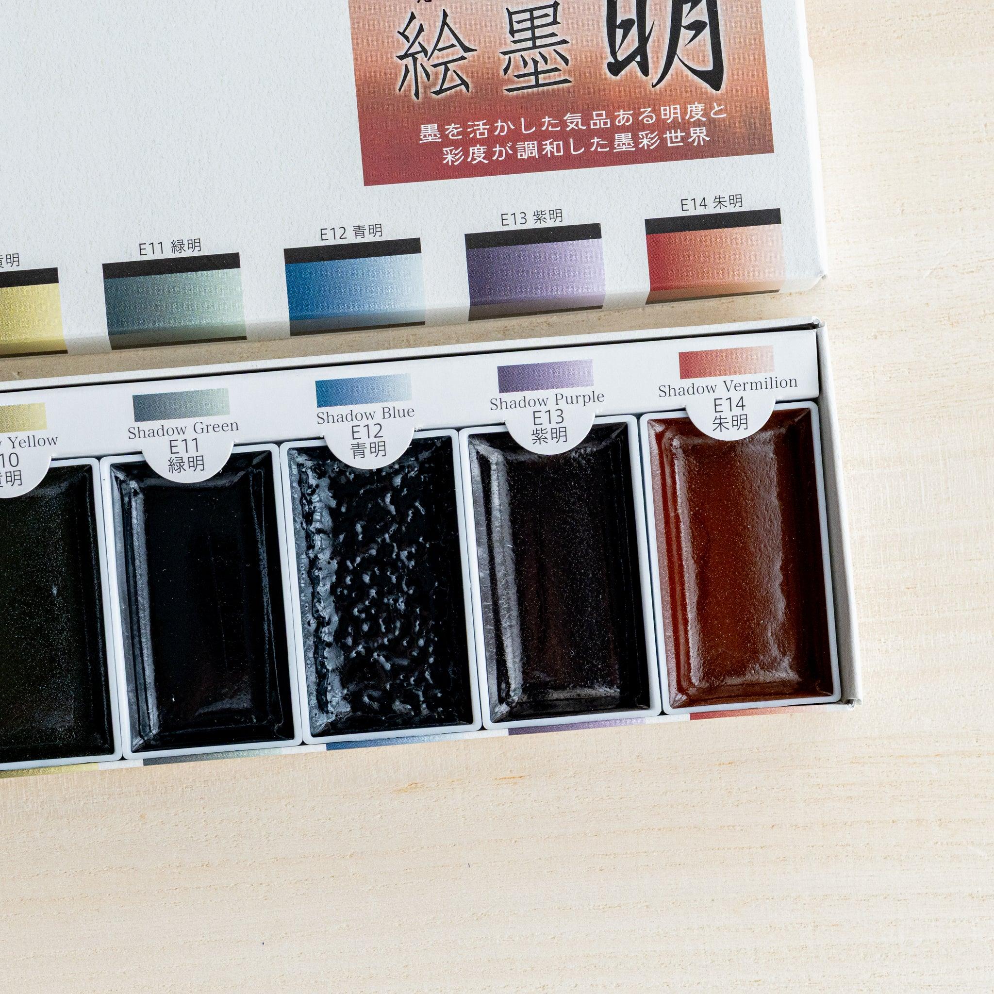 Close-up right half of open Bright Colors sumi ink watercolor box showing five colored pans labeled E10 to E14