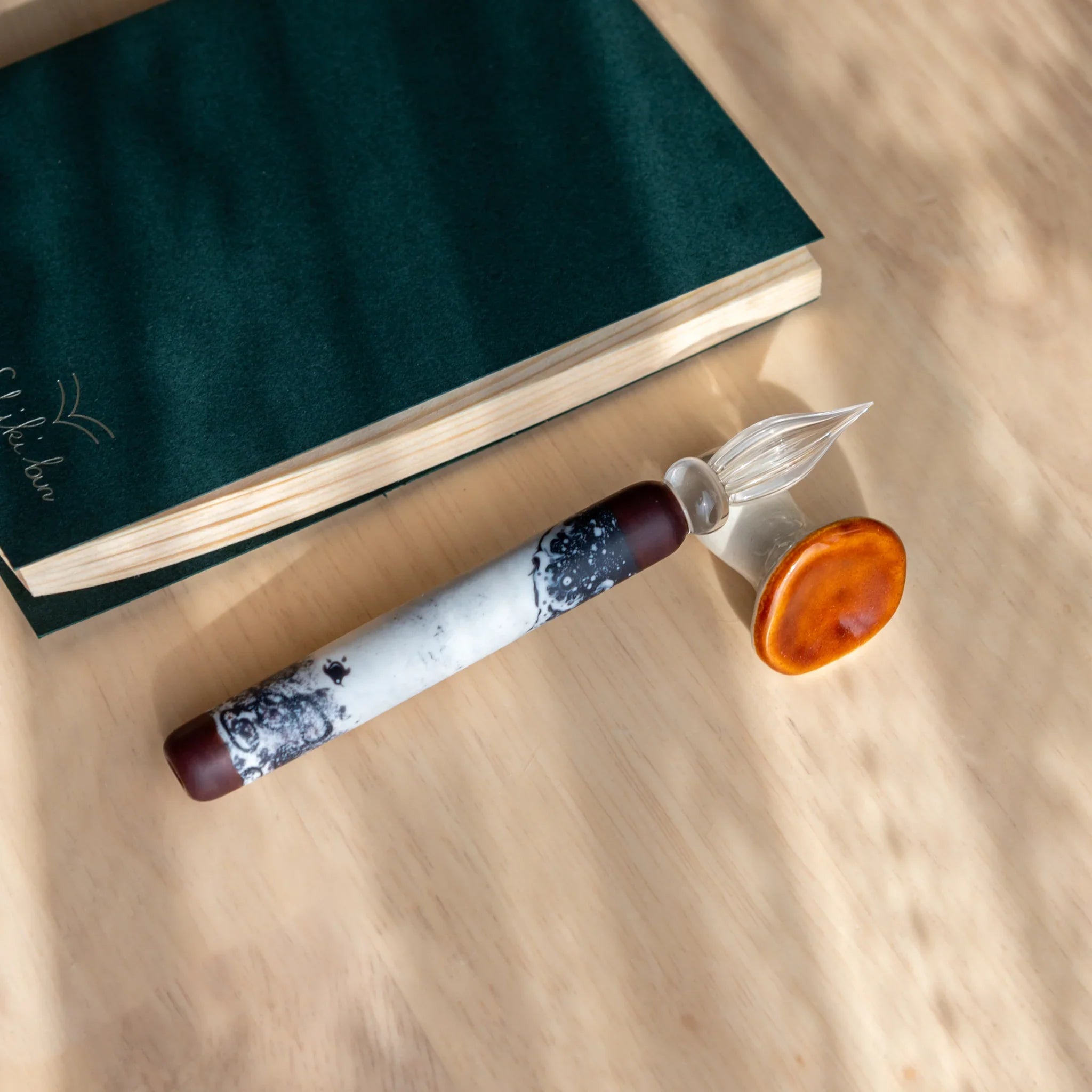 Brown mushroom ceramic pen rest with white stem accent, minimalist handcrafted Japanese design on wood close shot