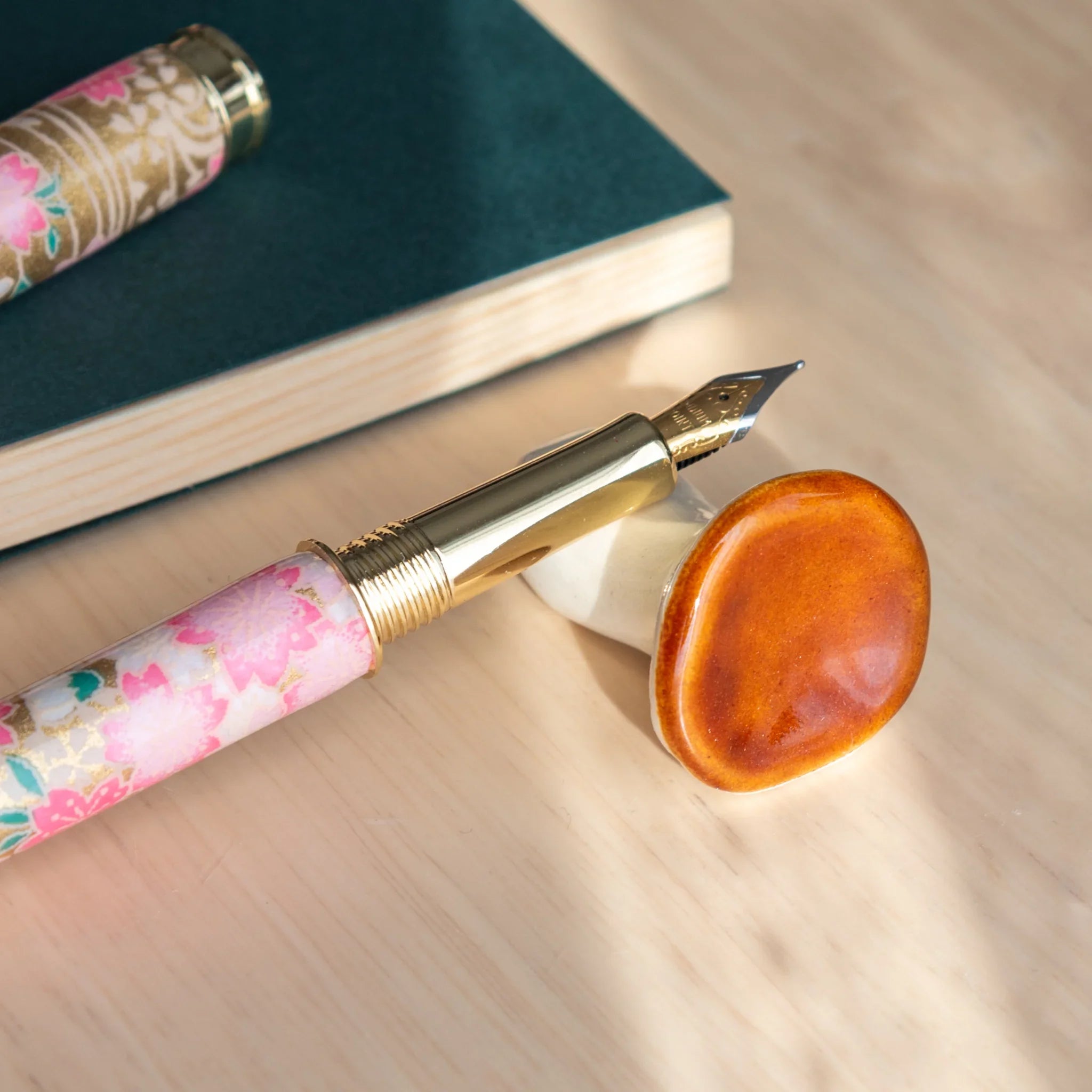 Small Japanese mushroom-shaped pen rest in warm brown tones with glossy ceramic handcrafted finish detail detail