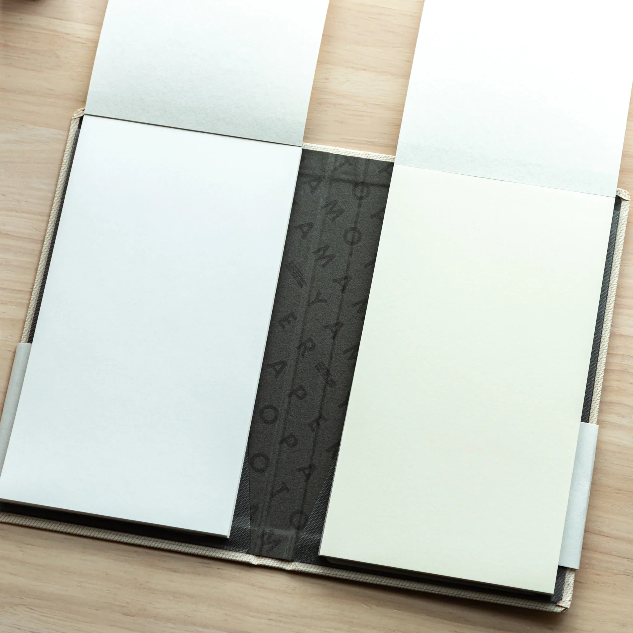 Bullet Jotter ivory white cover open, both pads with white pages facing up, Yamamoto Paper patterned spine visible at center