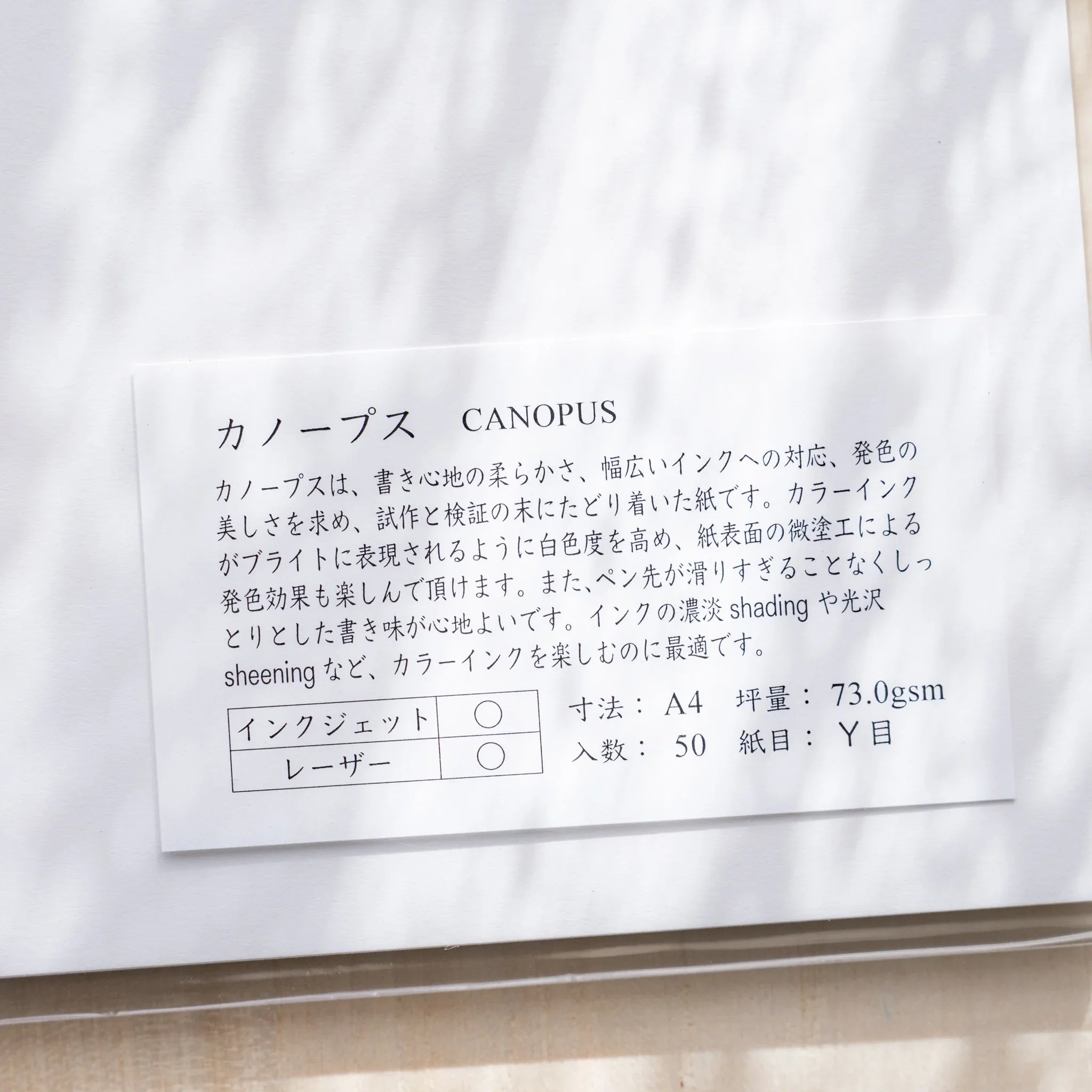 Close-up of Yamamoto Paper Canopus A4 loose leaf paper label showing 73gsm Y-grain 50-sheet specs in Japanese.