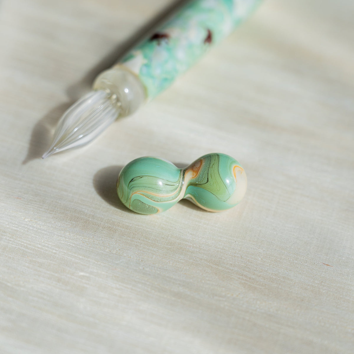 Two-sphere green glass pen rest with gold swirls, Chidori Mint Marble pen nib above it
