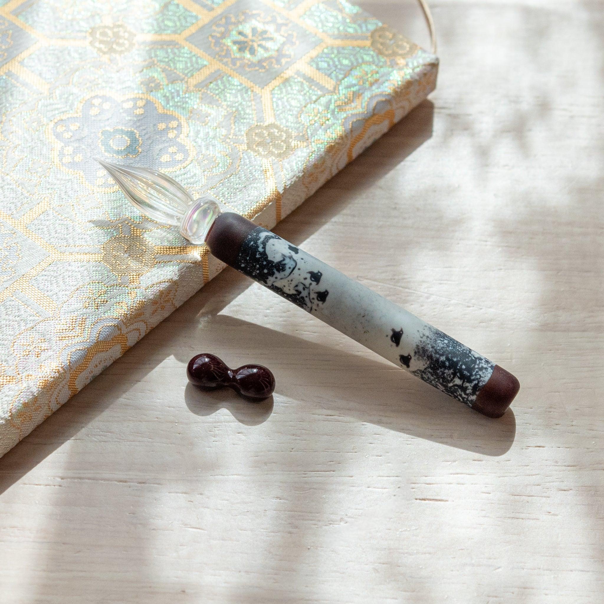 Flatlay display of Great Wave chidori glass dip pen with traditional Japanese wave and bird design elements set
