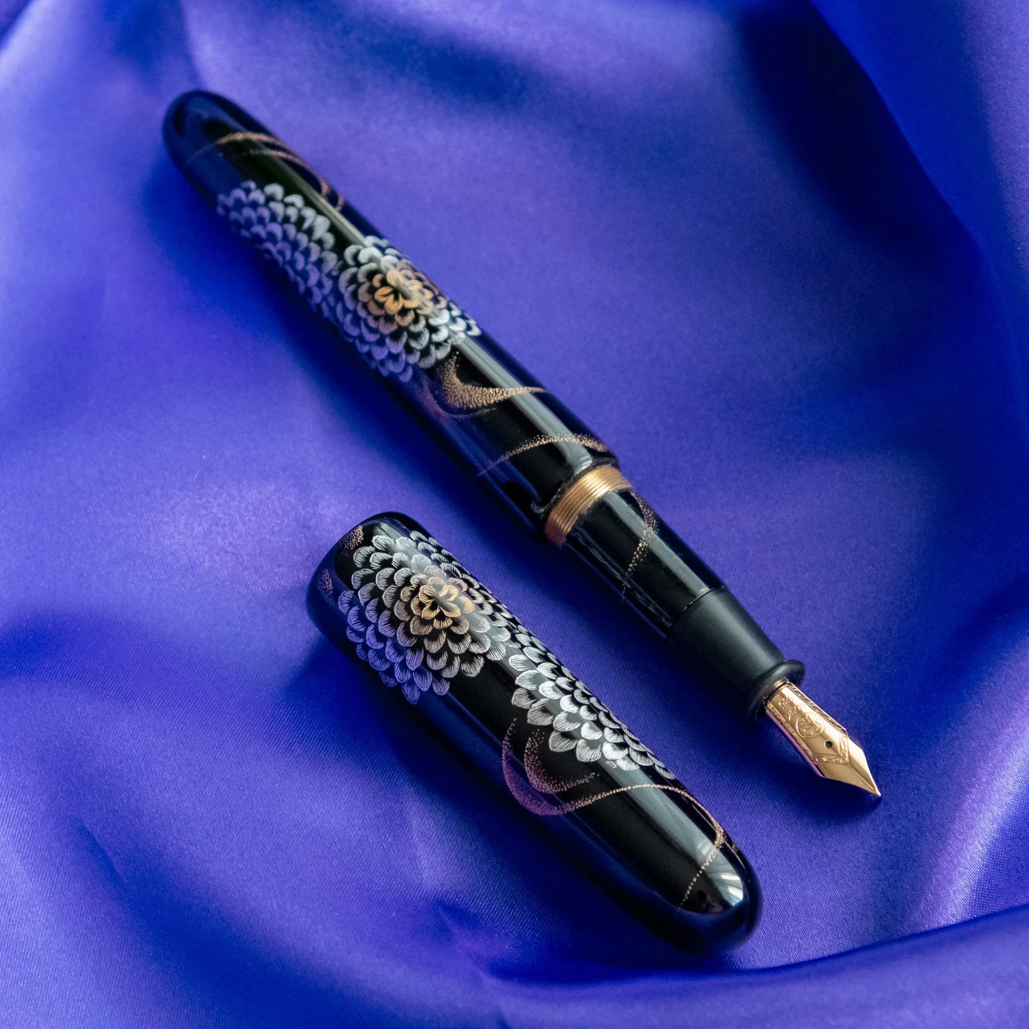 Open gift box revealing Chinkin Kikusui pen with blue silk backing and accessories showing product quality and design details