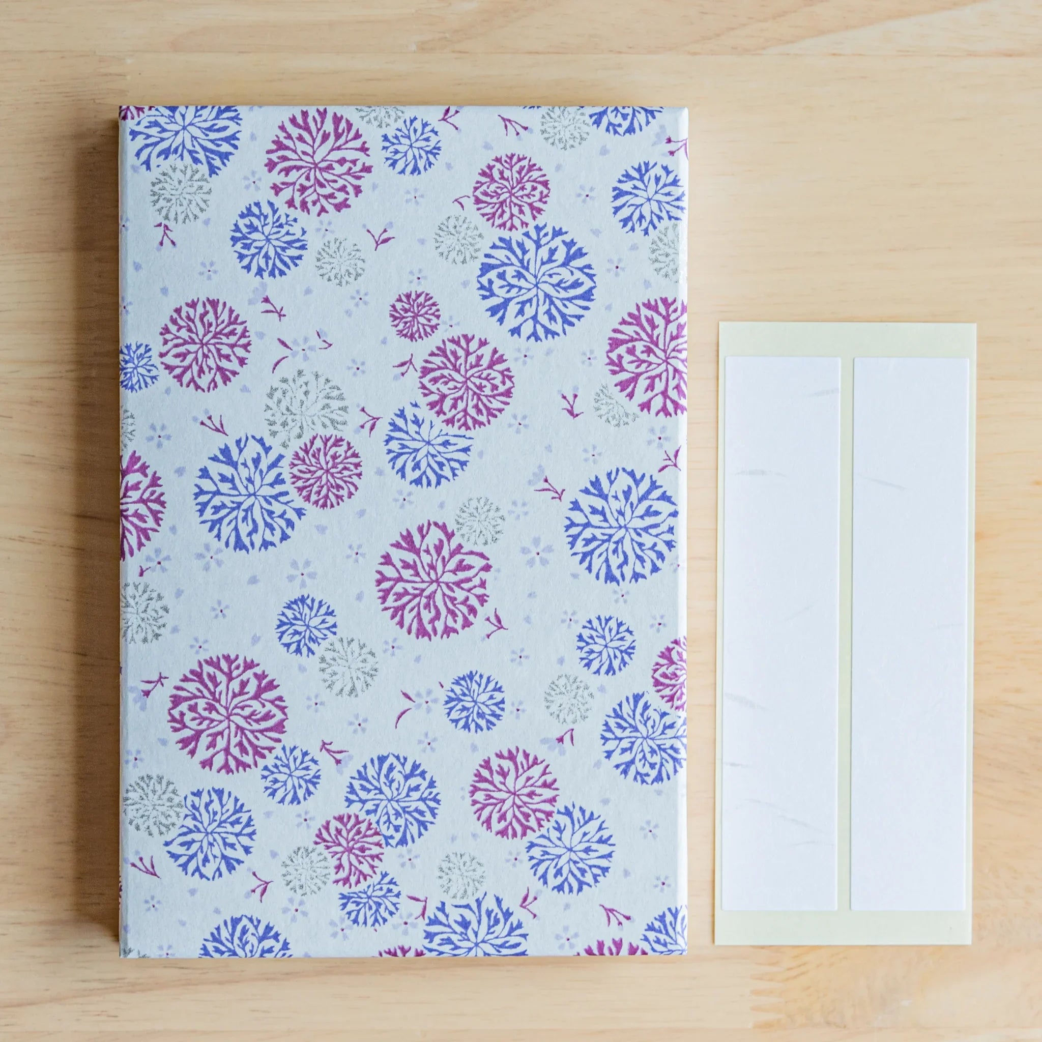 Closed Chrysanthemum Harmony purple goshuincho flat lay on wooden desk surface showing garden chrysanthemum pattern