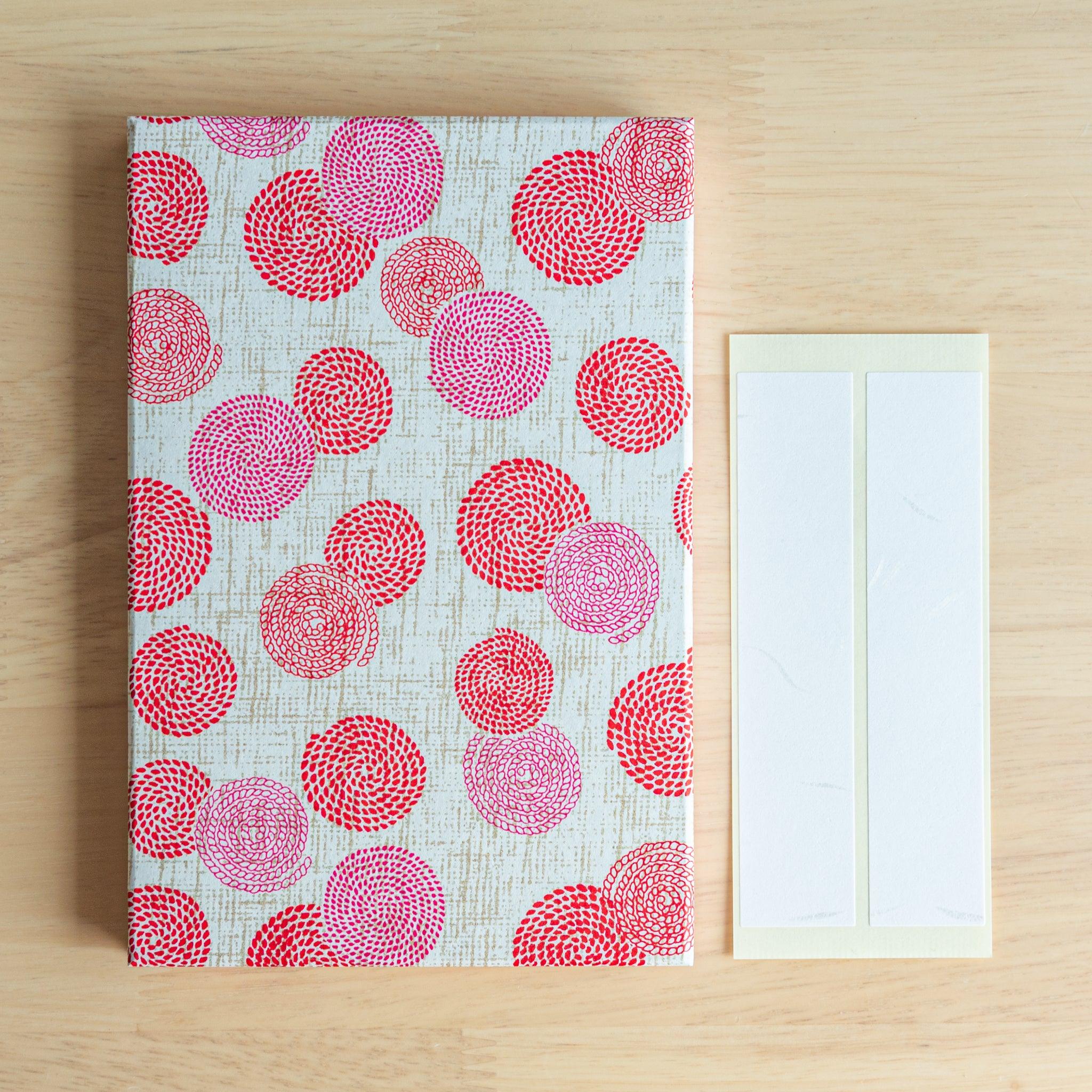 Japanese Goshuinsho stamp book with vivid red and pink blossom circles, includes label stickers for personalization.