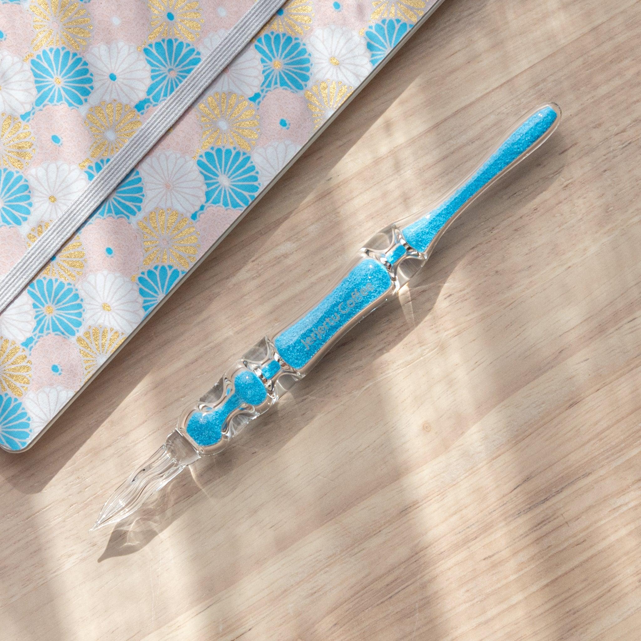 Cote d'Azur Hourglass Glass Dip Pen with colorful geometric chambers in blue and gold tones inside transparent glass