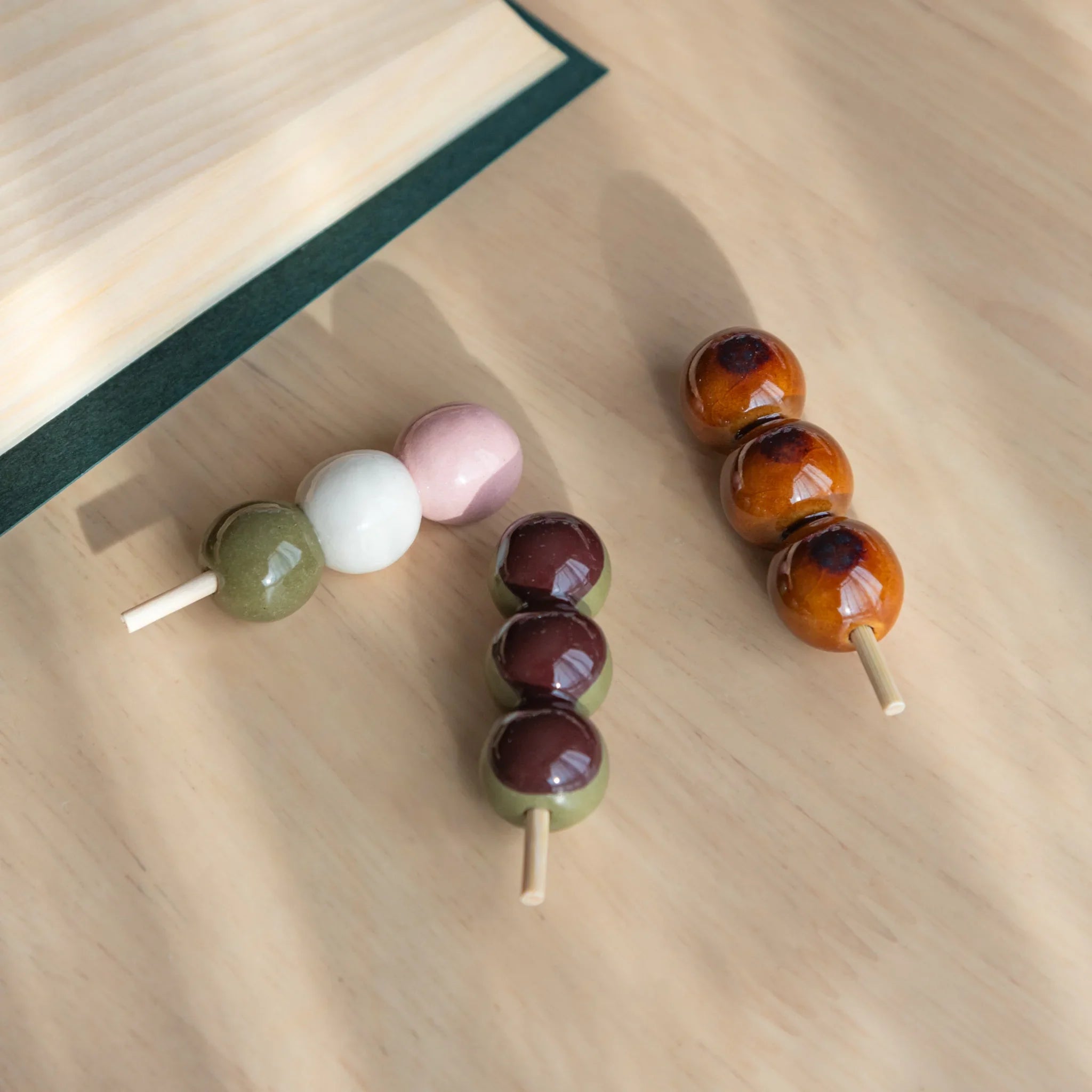 Brown toned dango pen rest with three beaded wooden spheres in warm chocolate and tan natural color palette finish