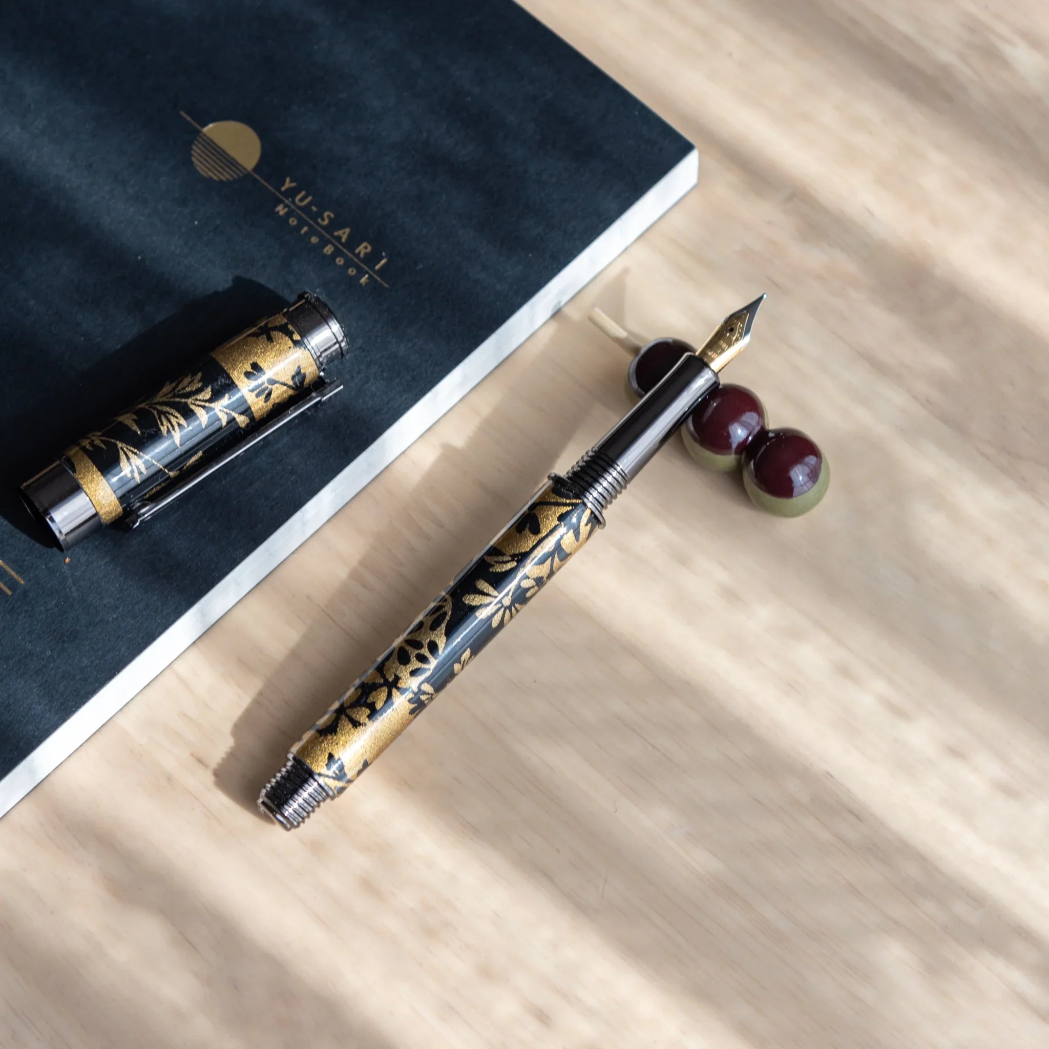 Brown and tan toned dango pen rest with three-ball stacked design showing natural earth color palette finish detail