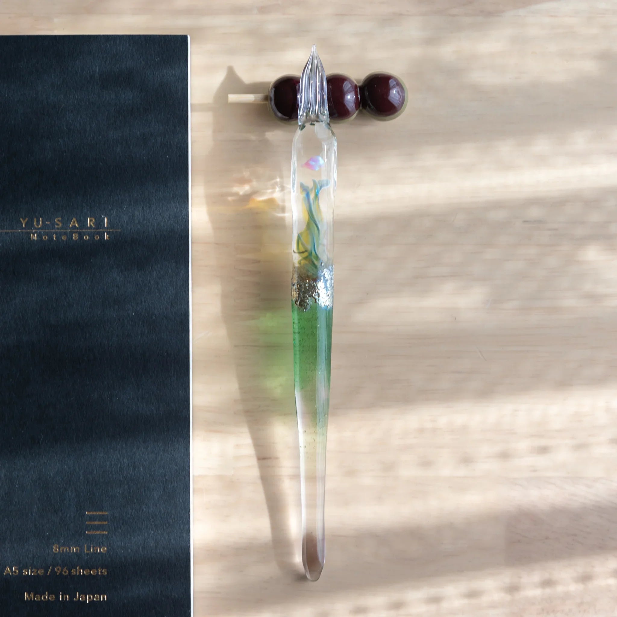 Rich burgundy three-sphere dango pen rest with handcrafted wooden beads in vertical stacked arrangement design