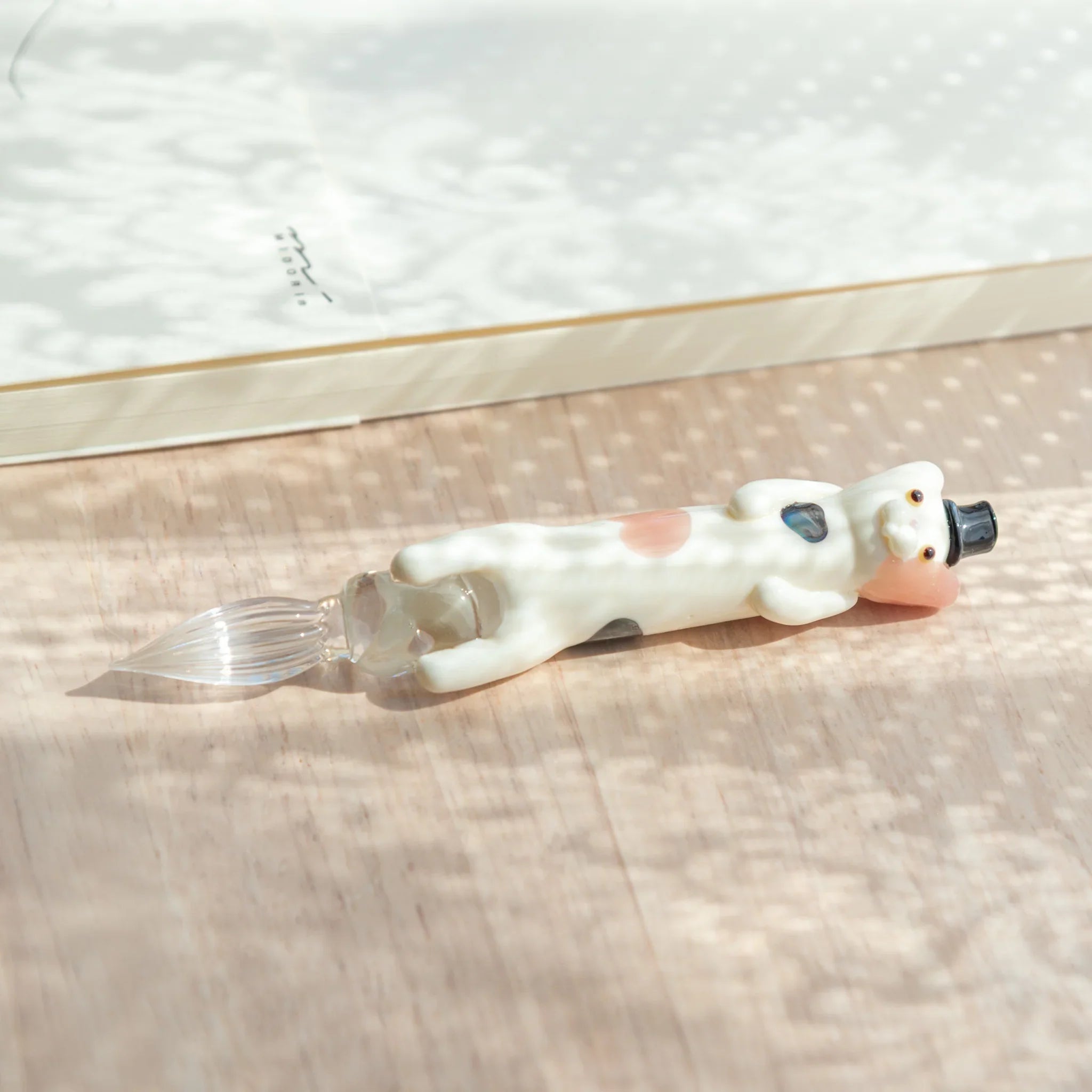 Dapper spotted cat glass dip pen with feline perched on vibrantly colored hand-blown glass bottle, Japanese glass pen