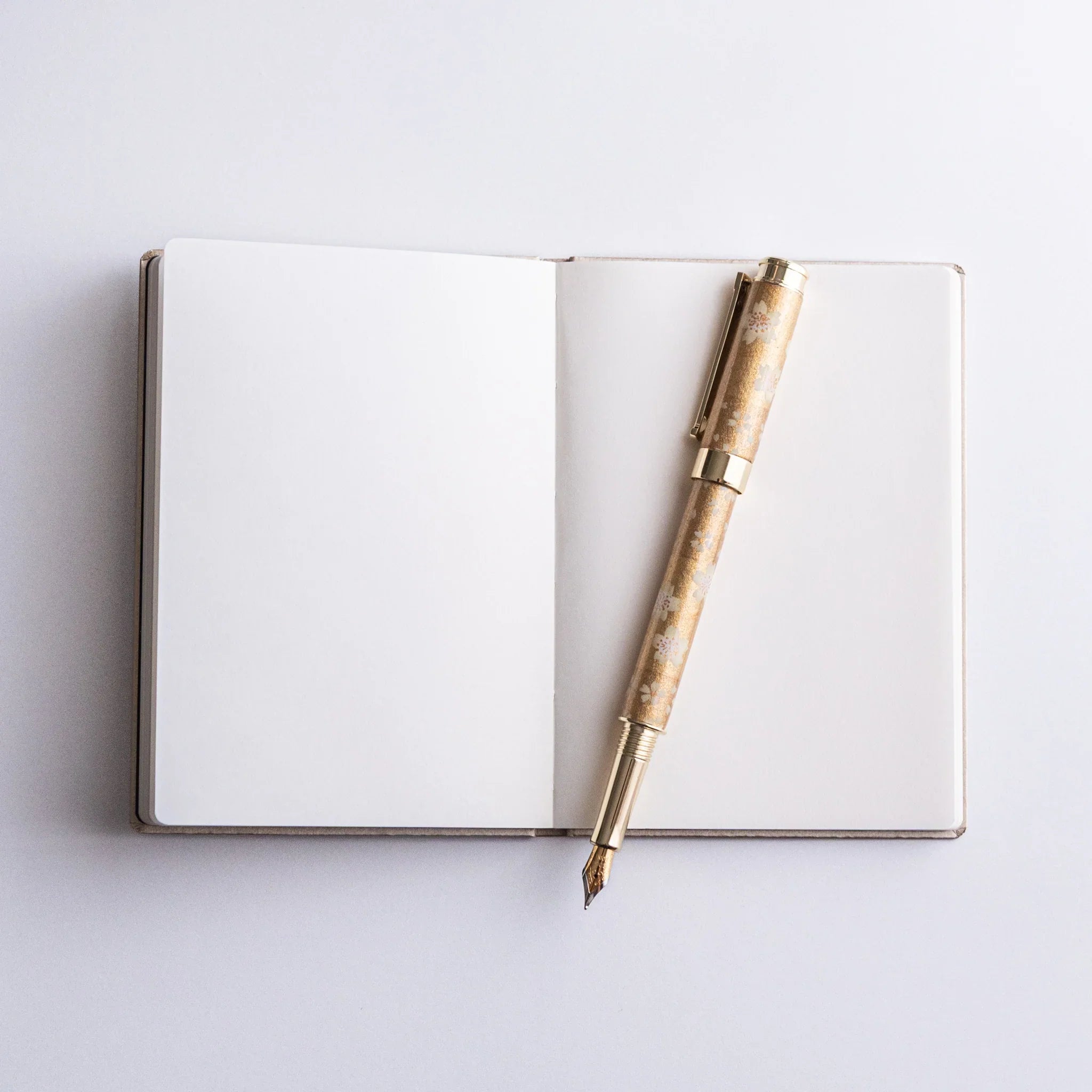 Dressco Bank Ledger Paper A6 notebook placed flat showing the cover face and stitched spine from a composition angle