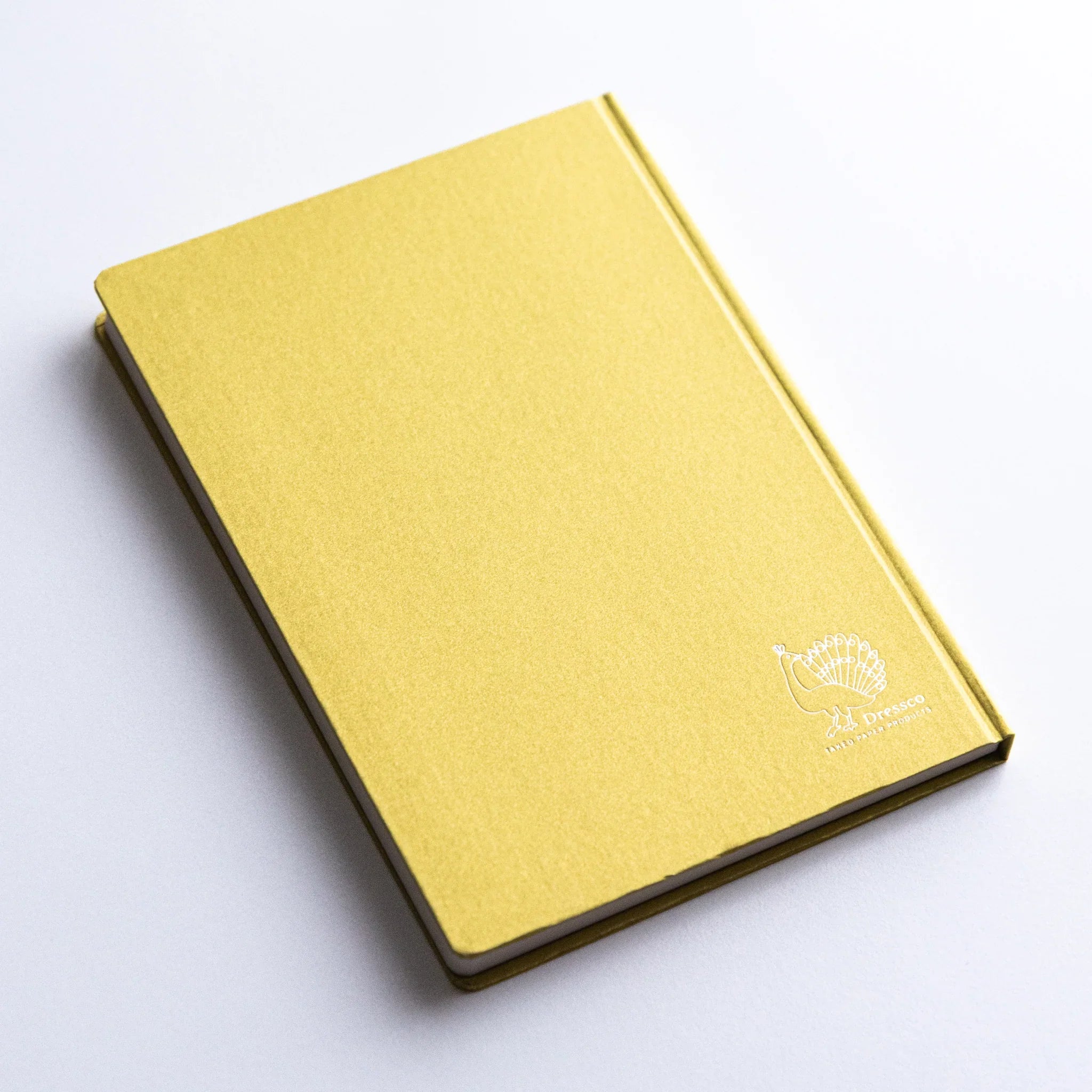 Textured cover close-up of Dressco Bank Ledger Paper A6 notebook showing the surface material and paper edge detail