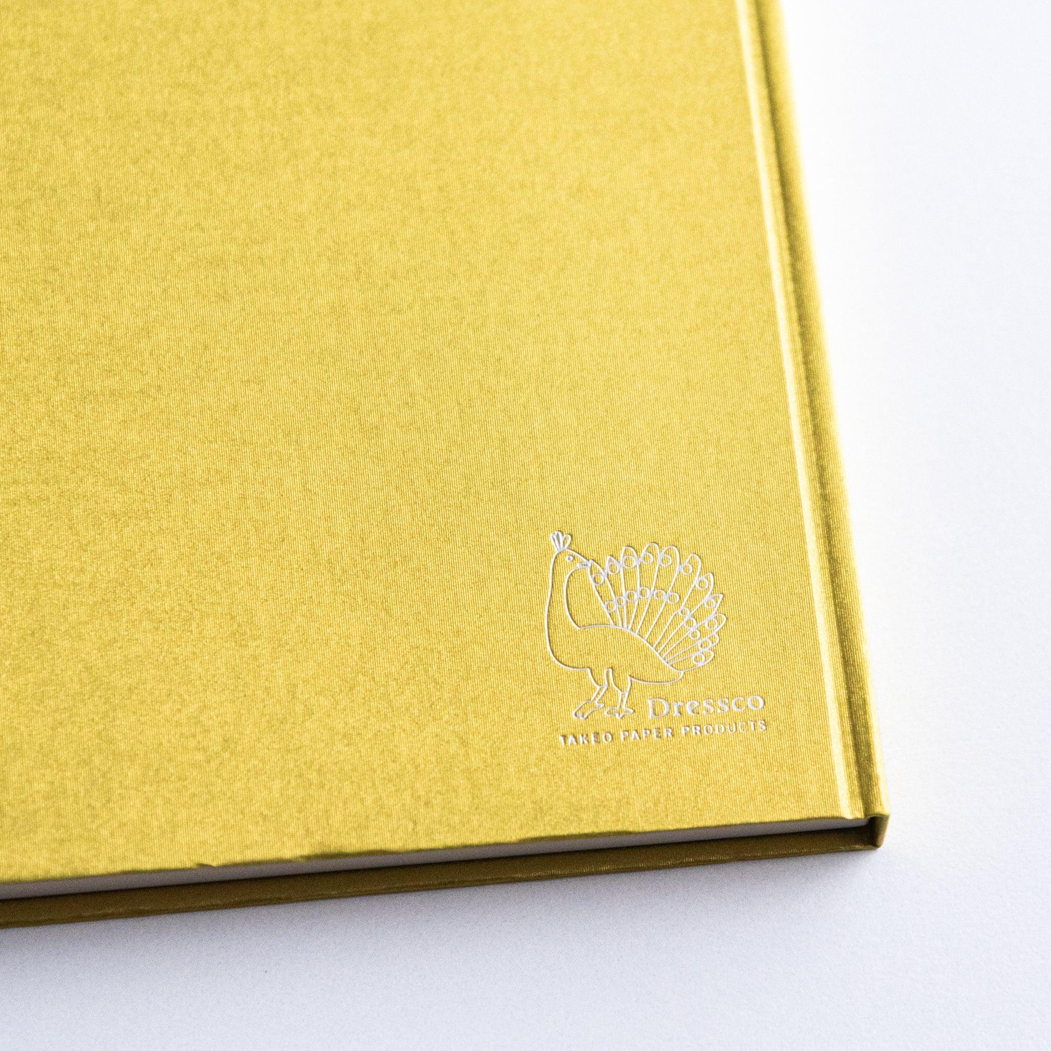 Detail shot of embossed logo on Dressco Bank Ledger Paper Japanese Notebook in Gold.